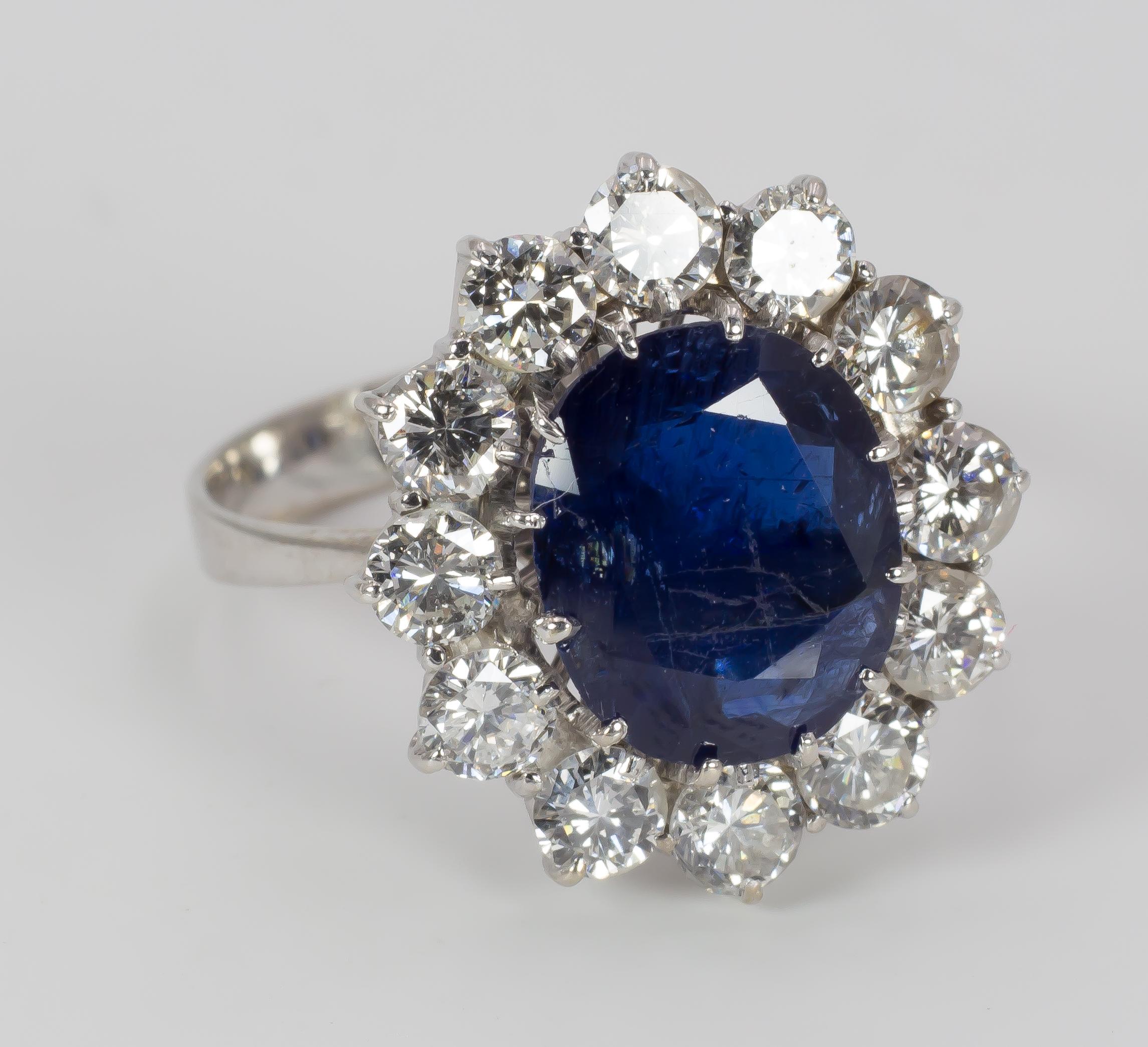 This stunning classic cluster vintage ring, dating from the 1950s, remembers the one belonged to Lady Diana first and to Kate Middleton, Duchess of Cambridge then. 
It features a beautiful central 3.5ct blue sapphire, surrounded by a halo of 2ct ca.