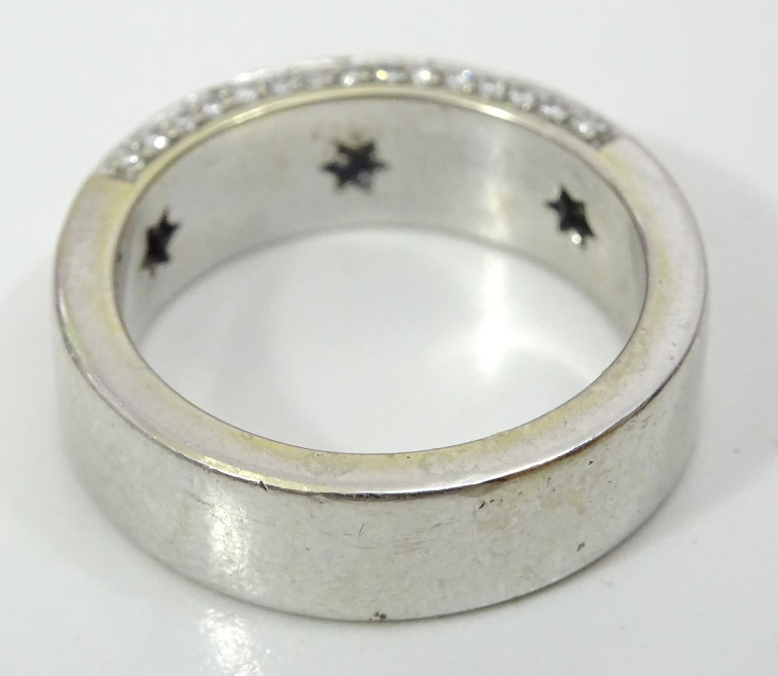 This is a very classy and elegant ring manufactured in the 1960's - 70's.
 It is made in 18 karat white gold and is set with approximately 120  1 point diamonds on the front  and on the side of the shank of the ring in a pave setting and a further 6