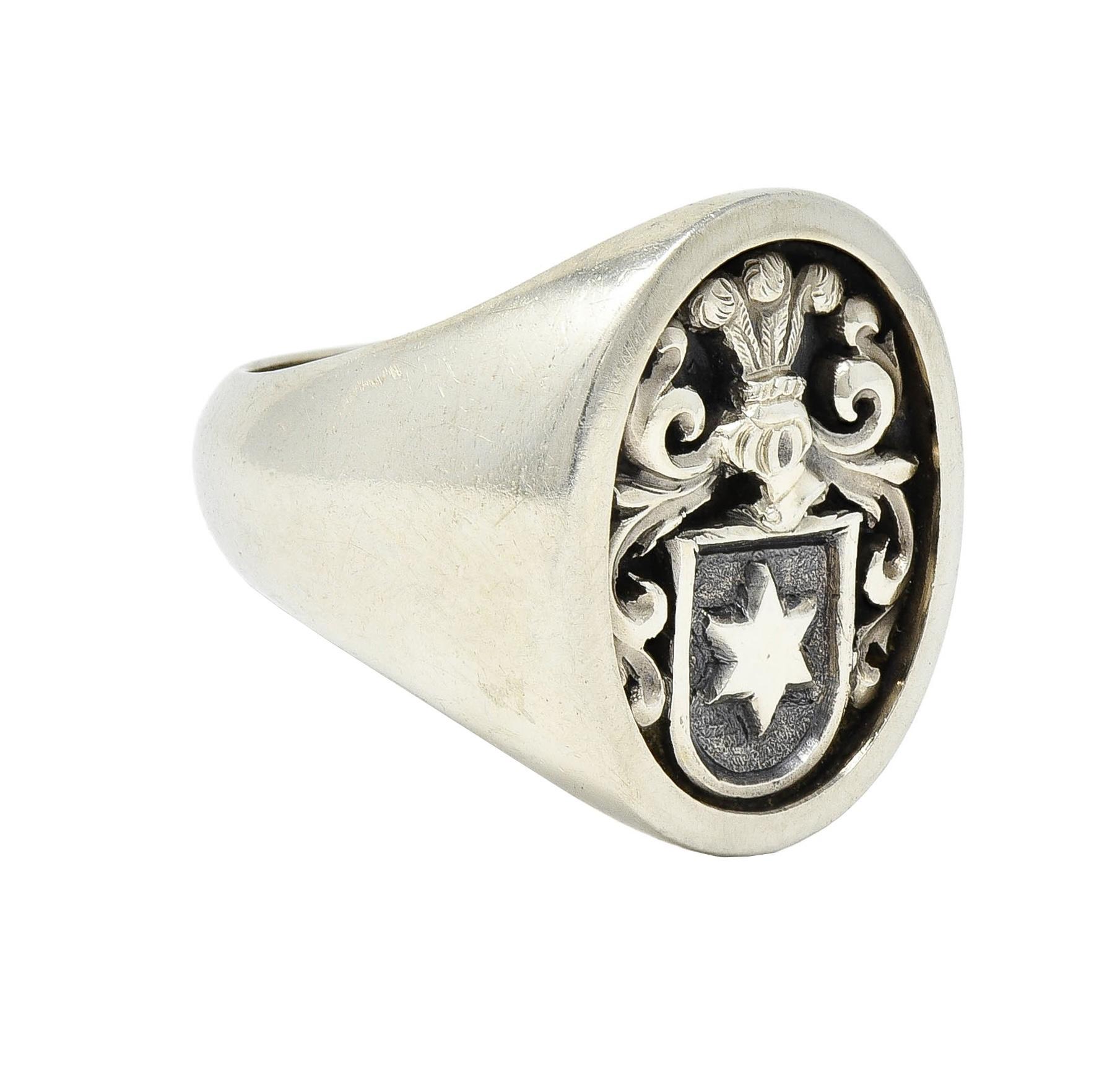 Designed with an oval-shaped face featuring a recessed cameo 
Depicting a knight's helmet with scrolls and star motif shield 
Representing the Haggard family coat of arms
With sleek, slightly rounded shoulders
Stamped for 18 karat gold
With maker's