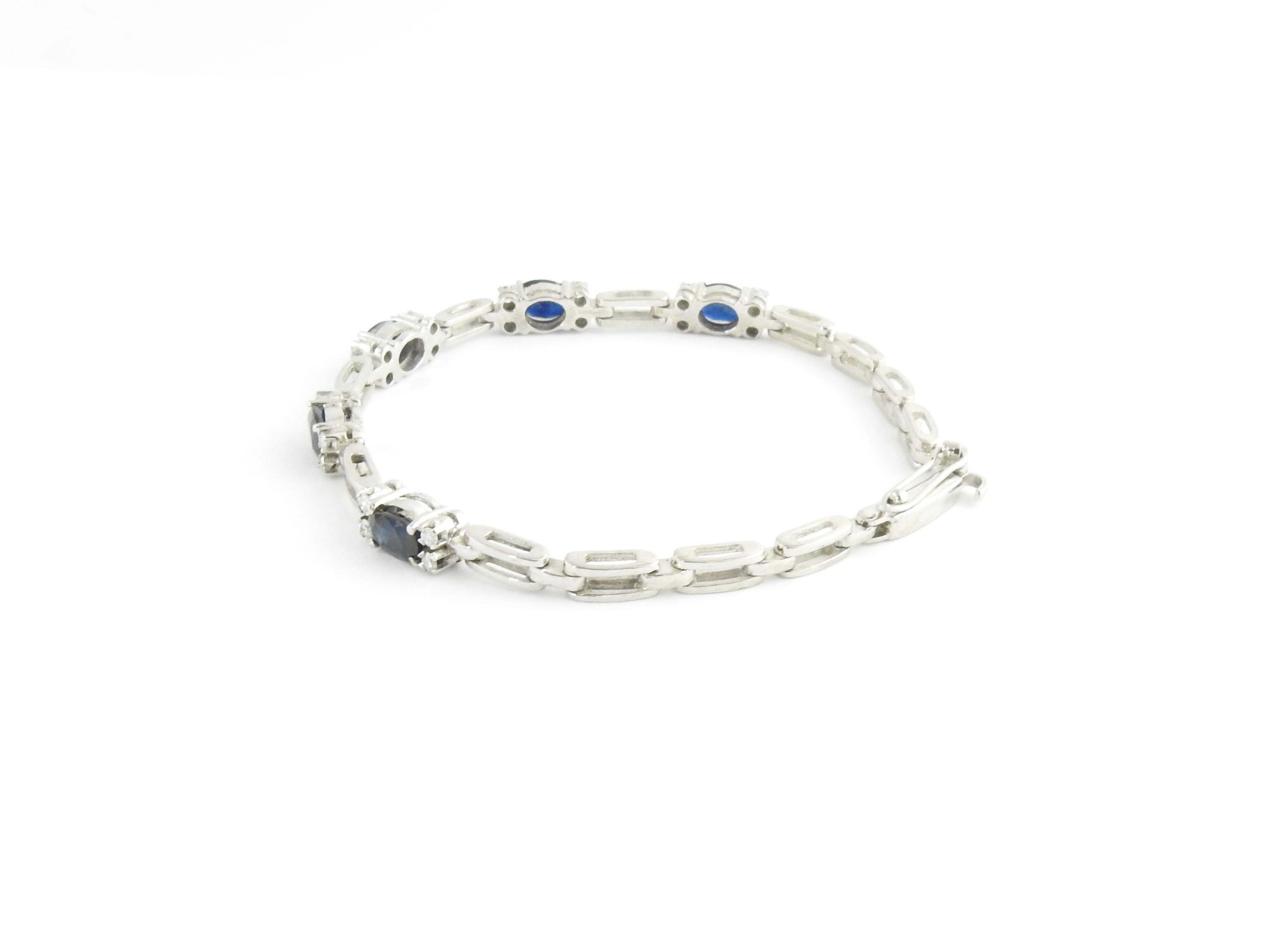 Vintage 18 Karat White Gold Sapphire and Diamond Bracelet-

This stunning bracelet features five oval sapphires* (7 mm x 5 mm each) and 20 round brilliant cut diamonds set in beautifully detailed 18K white gold.  Width:  5 mm.
*Some chips noted not