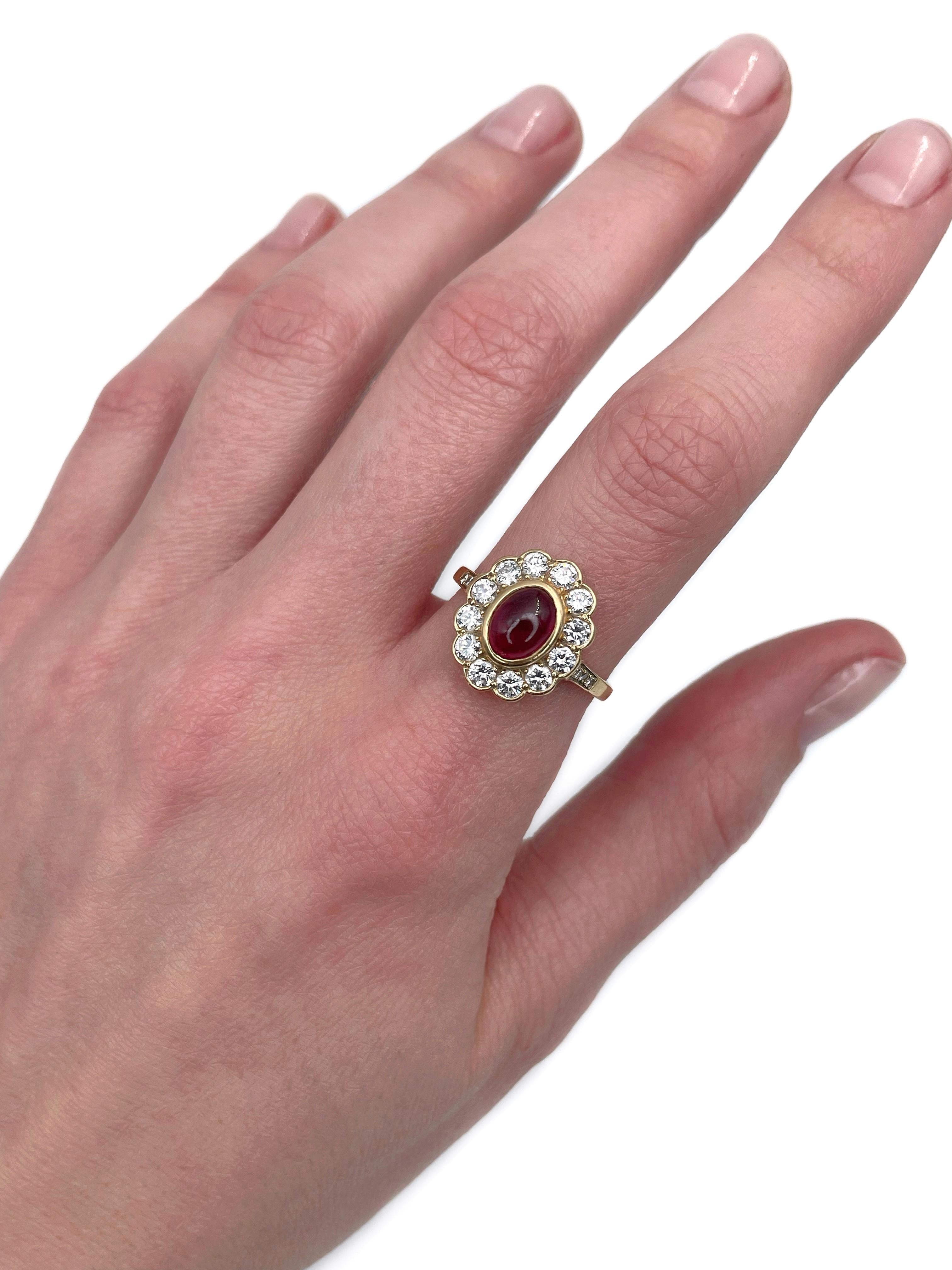 This is a vintage cluster ring crafted in 18K white gold. Circa 1970. 

The piece features:
- 1 ruby (oval cabochon cut, 1.90ct, slpR 6/4, SI)
- 20 diamonds (round brilliant cut, TW 1.00ct, RW+/W, VS-SI)

The ball inside the shank keeps the ring