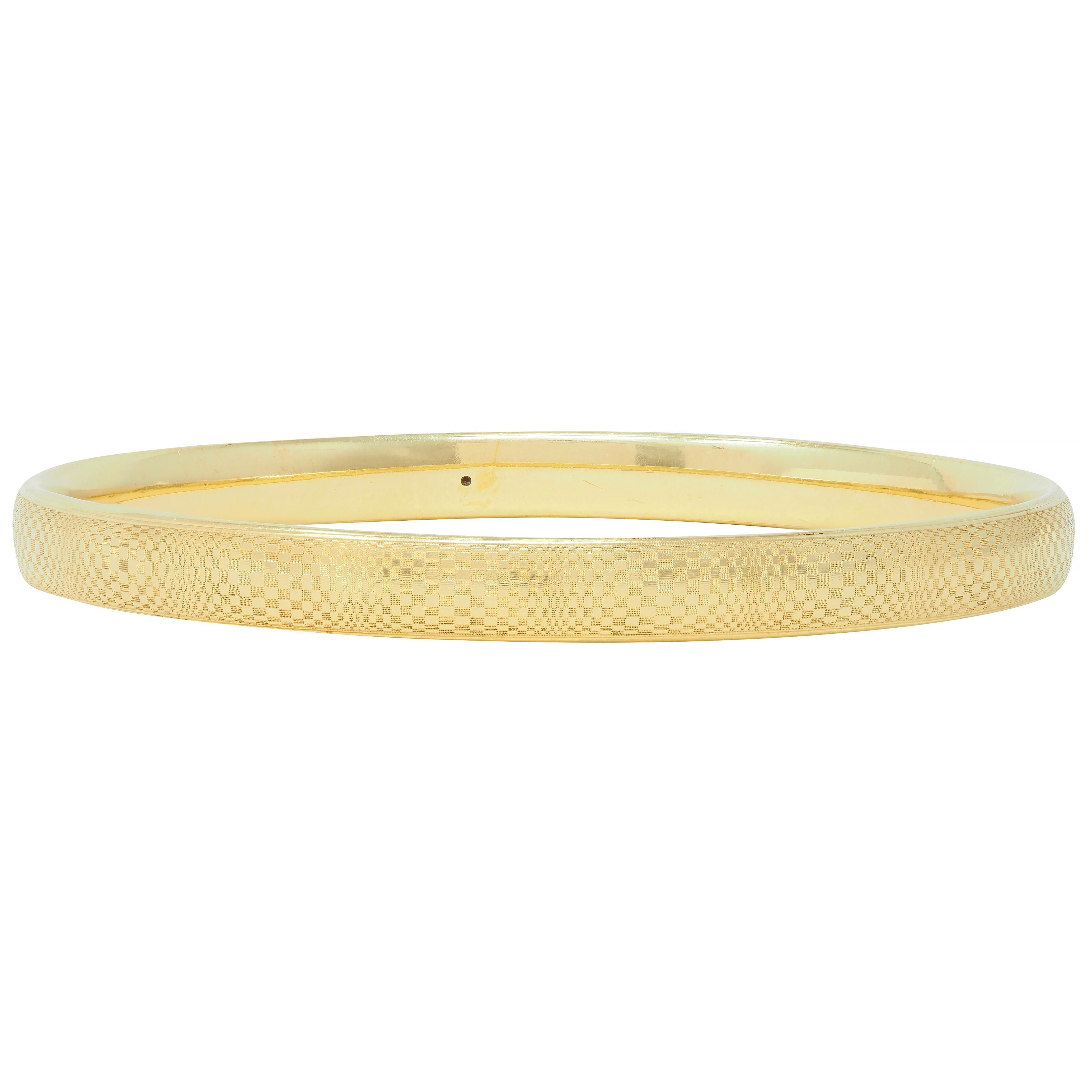 Designed as a round bangle bracelet with an intricately engraved checkerboard pattern
Abstracted with spherical optical allusion quality fully around 
With ridged edges
Stamped for 18 karat gold
Circa: 20th century 
Width at widest: 1/4