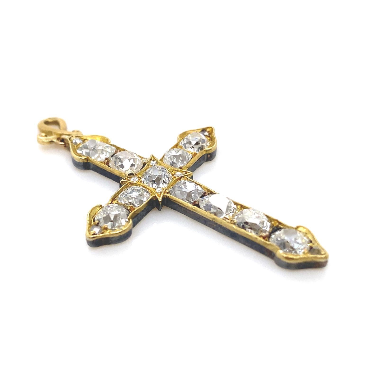 Pendentif en forme de croix en or jaune 18 carats et en argent serti de diamants.

La croix est composée de 11 diamants anciens en forme de coussin et de losange, sertis de griffes et de grains, et de petits diamants taillés en rose à chaque