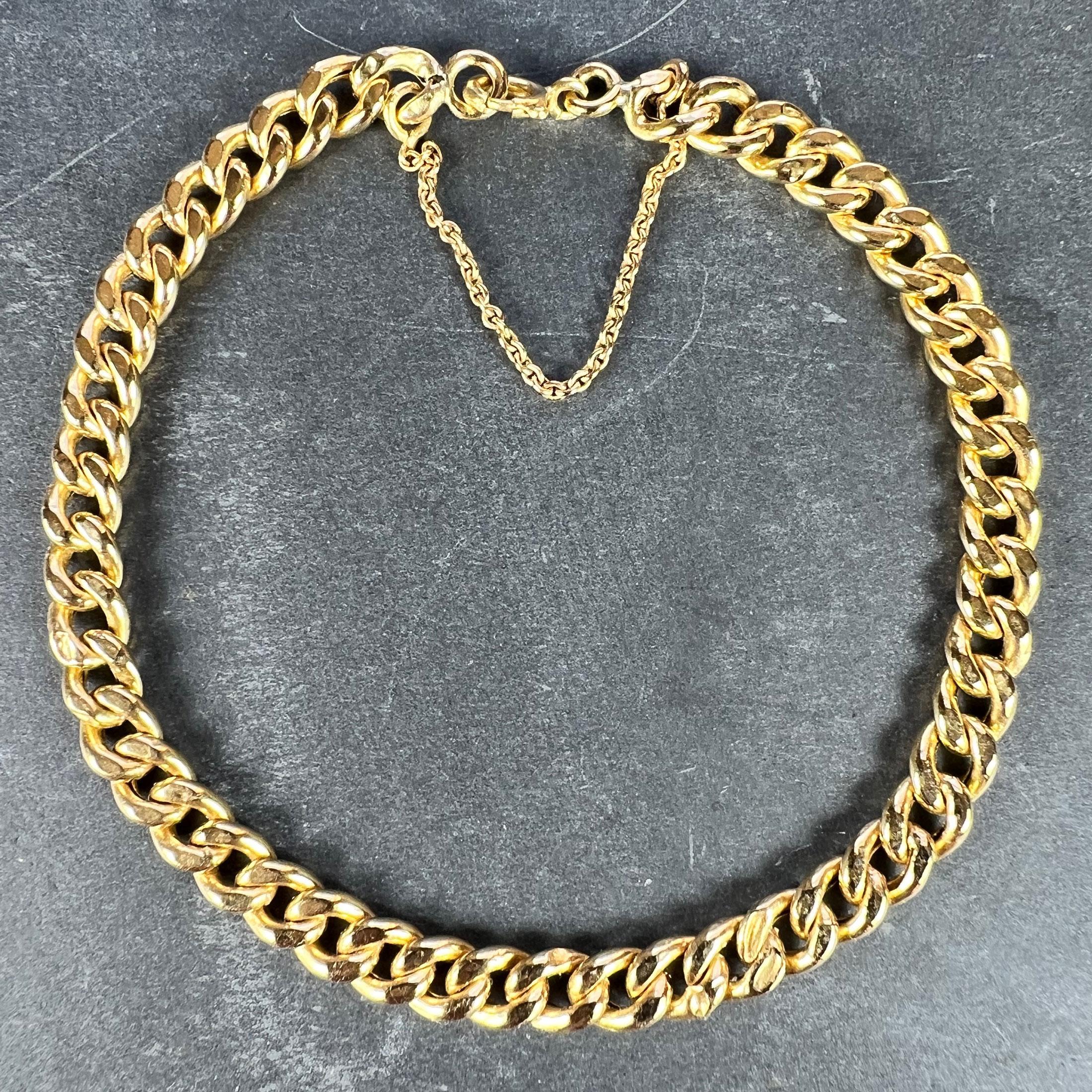An 18 karat (18K) yellow gold curb link chain bracelet with hollow curb links and a spring ring clasp. Fitted with a safety chain to the clasp. Stamped with the French import mark and 750 for 18 karat gold. Some slight dents to the