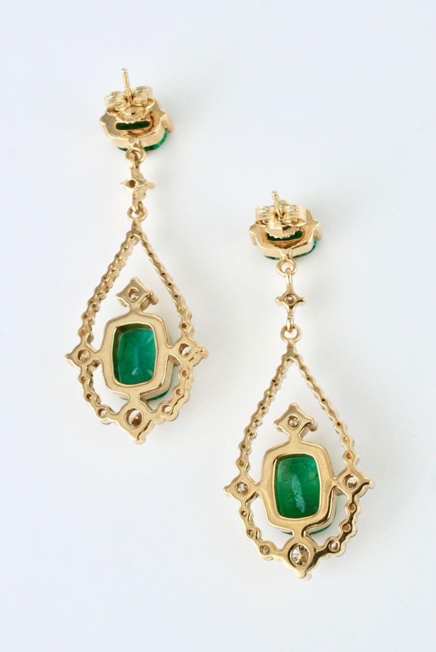 A pair of 18k yellow gold emerald and diamond drop earrings with each earring consisting of a natural untreated cushion cut emerald four claw set within a drop shape of round brilliant cut diamonds set in yellow gold suspended below a smaller