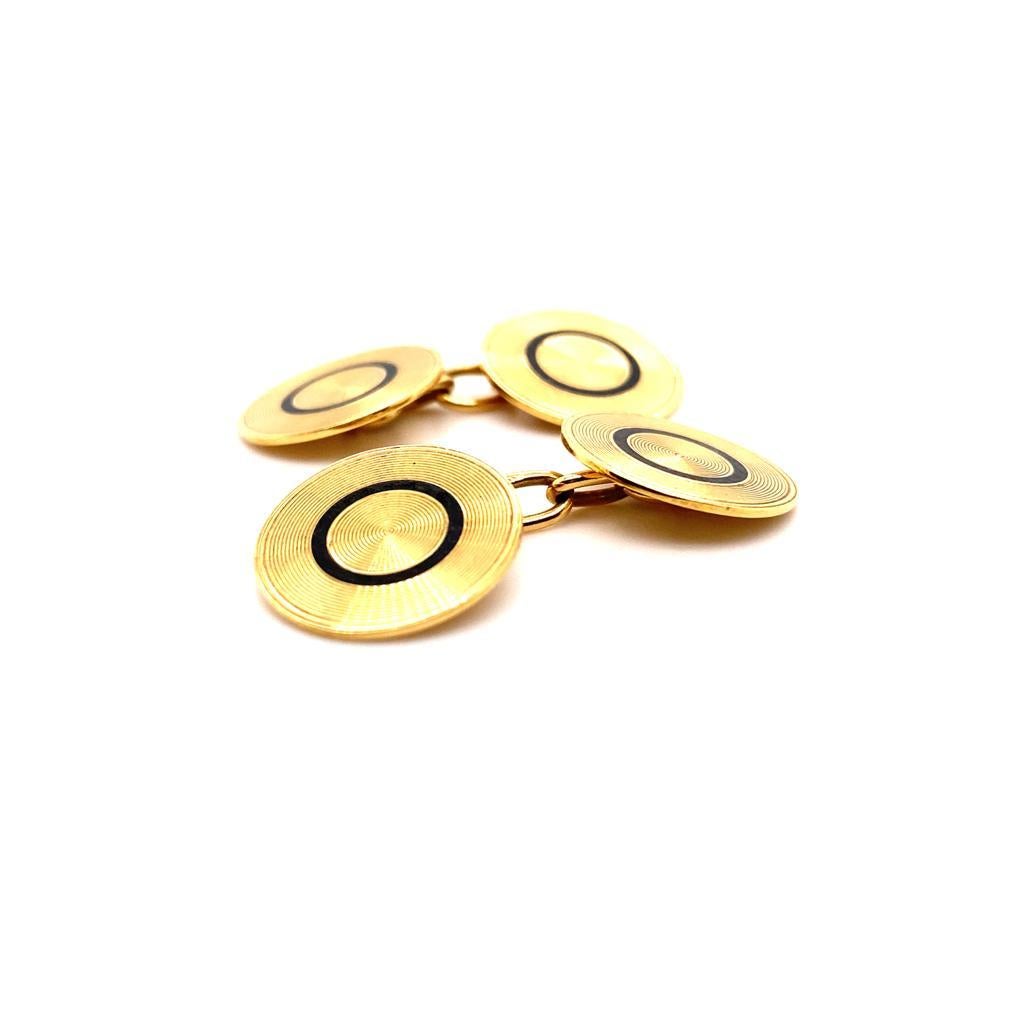 A pair of vintage 18 karat yellow gold circular cufflinks, circa 1950.

These classic vintage cuff links are designed as matching yellow gold discs featuring a series of engine turned concentric circles. Each interspaced with black enamel detail.