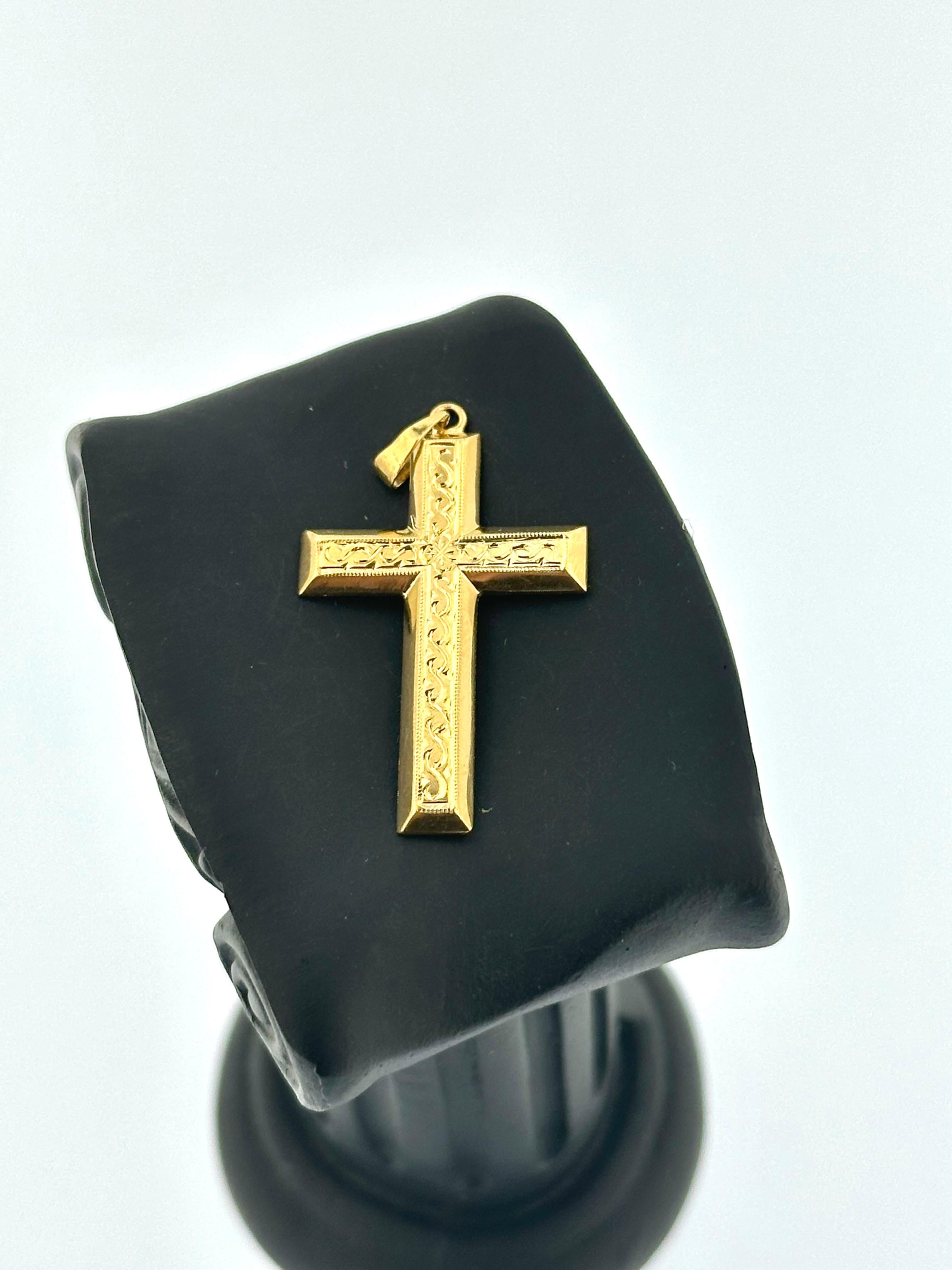Dieses französische Kreuz im Vintage-Stil ist ein wunderschönes Stück aus 18-karätigem Gelbgold mit einer exquisiten Reliefarbeit, die dem Design Tiefe und Textur verleiht. Das Kreuz weist auf seiner Oberfläche komplizierte, erhabene Muster auf, die