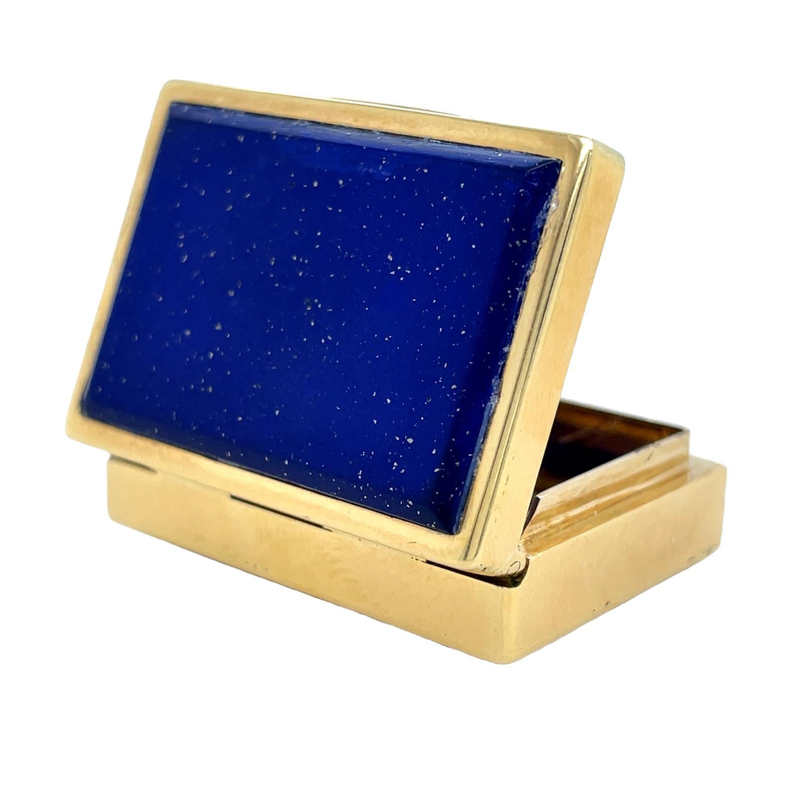 Boîte à pilules vintage en or jaune 18 carats et lapis-lazuli, vers 1970

Une jolie boîte à pilules de forme rectangulaire dont le couvercle et la base sont sertis de lapis-lazuli cabochon délicatement moucheté de mèches dorées distinctes de