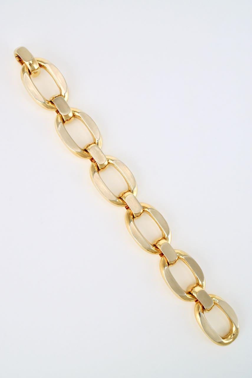 An 18k yellow gold chain oval link bracelet comprised of 6 large oval links joined with smaller domed links with flat polished surfaces and finished with an integrated hinged dome clasp - this is a luxe large scale design from one of the best