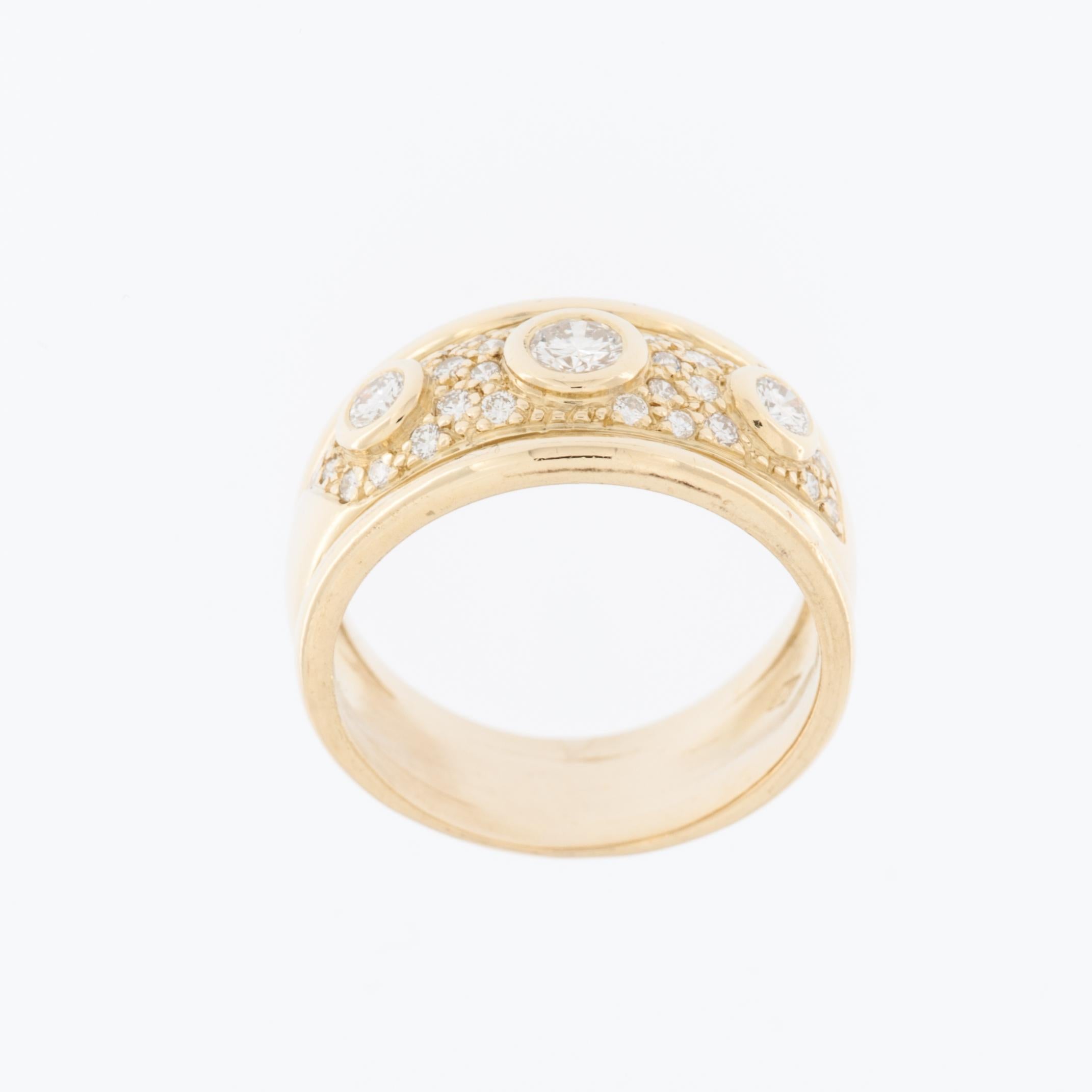 Bandbreite: ca. 10,8 mm

Dieser exquisite Vintage-Ring ist aus 18 Karat Gelbgold gefertigt und zeigt ein raffiniertes Schweizer Design. In der Mitte des Bandes befinden sich drei größere natürliche Diamanten, die in einer glatten Lünette gefasst