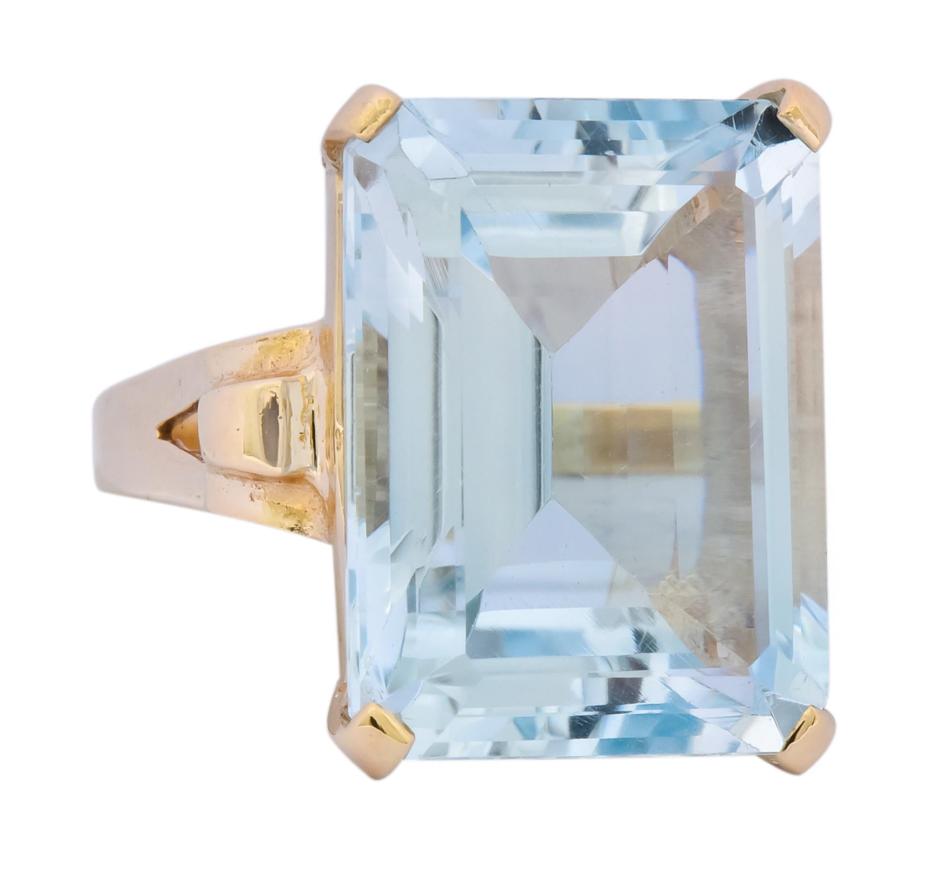 Centering a rectangular step cut aquamarine weighing approximately 18.00 carats, transparent and very light sky blue color

Prong set in a cathedral basket style mounting with domed, scrolled shoulders

Stamped 14k for 14 karat gold

Ring Size: 6