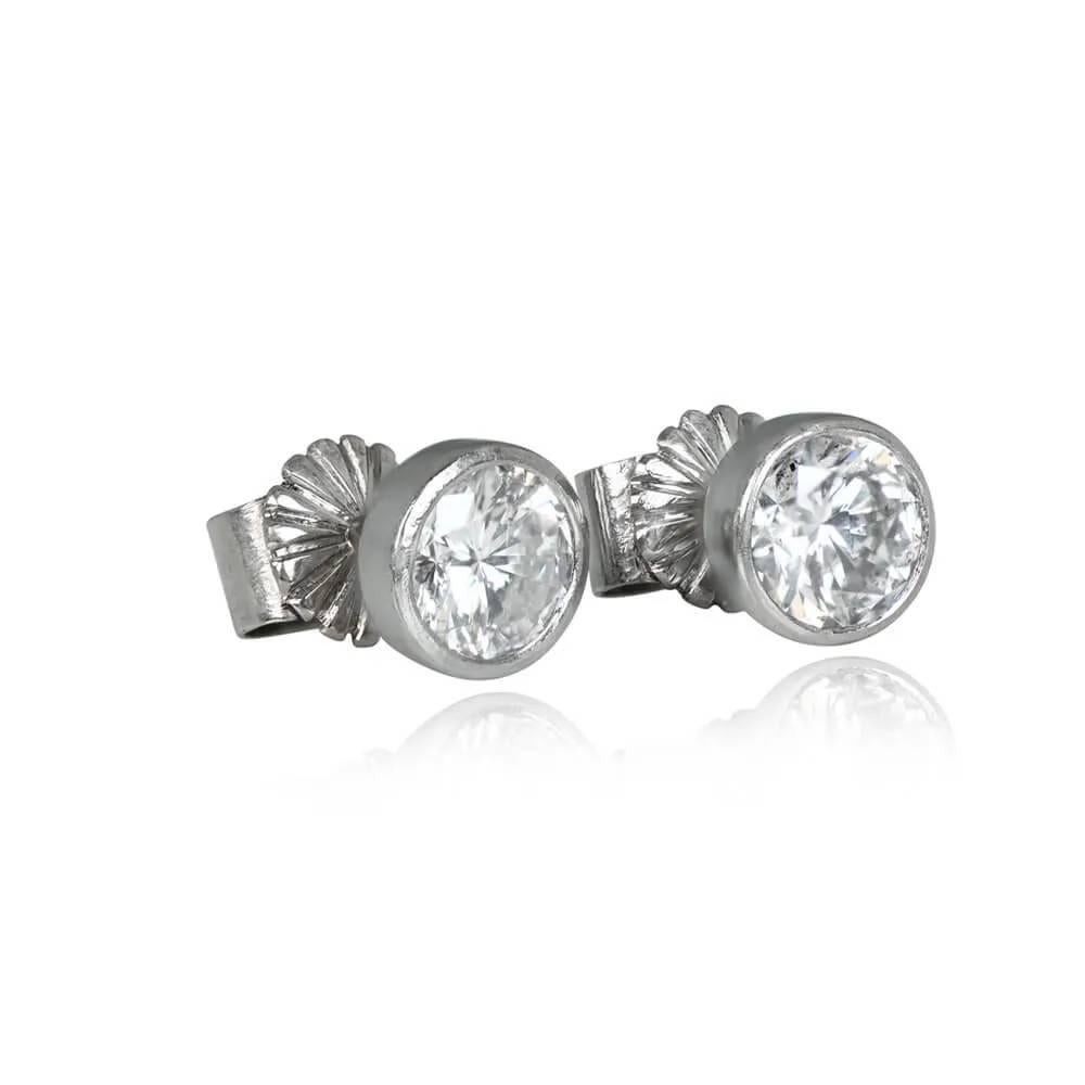 Vintage elegance exudes from this pair of platinum earrings showcasing two bezel-set round brilliant cut diamonds with a combined weight of 1.80 carats, H color, and I1 clarity. Handcrafted circa 1980, these earrings are completed with push-back