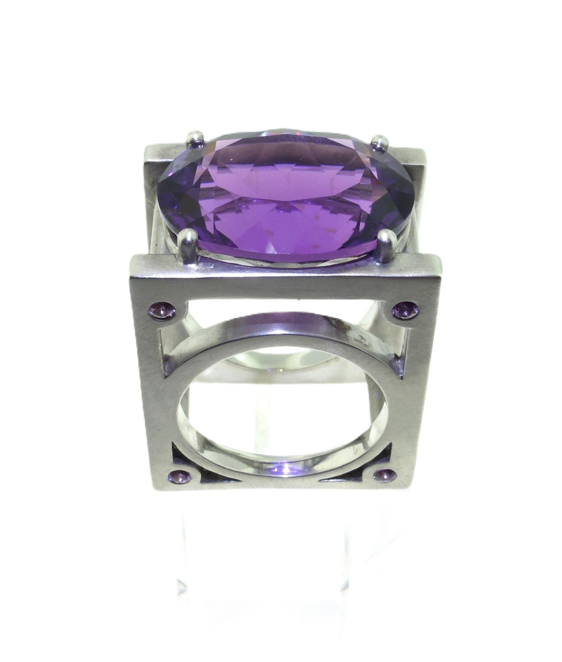 Simply Beautiful! Fabulous Architectural Solitaire Amethyst Cocktail Ring. Featuring a Hand set 18.22 Carat Oval Amethyst, measuring approx. 20mm x 15mm. Each corner enhanced with a Hand set Round 2mm Lavender Sapphire. The 4 Lavender Sapphires,