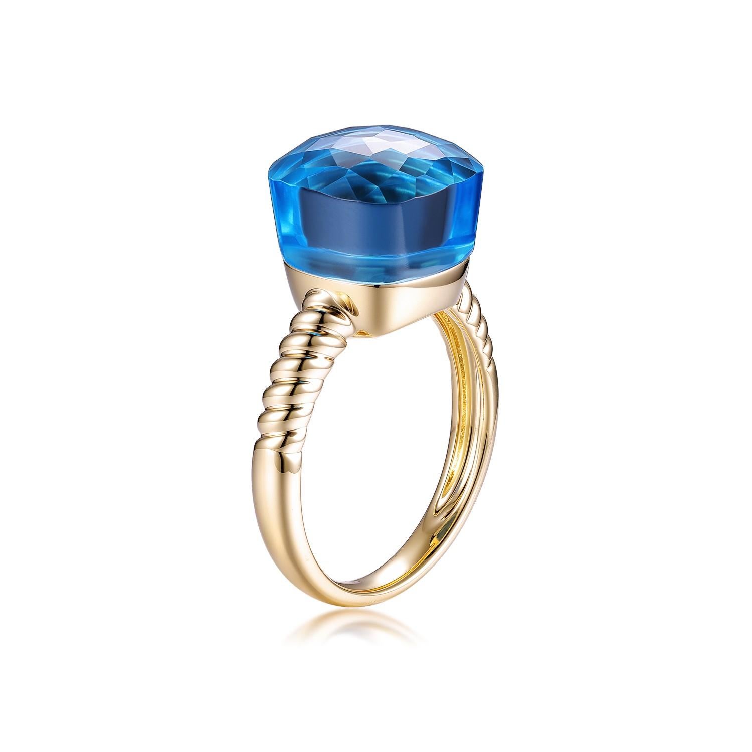 Questo squisito anello in oro presenta un ipnotico topazio blu da 18,3 carati con taglio a cuscino, incastonato in una lussuosa fascia in oro giallo 14k.  Il topazio blu, di grandi dimensioni e di grande impatto, vanta una tonalità radiosa e