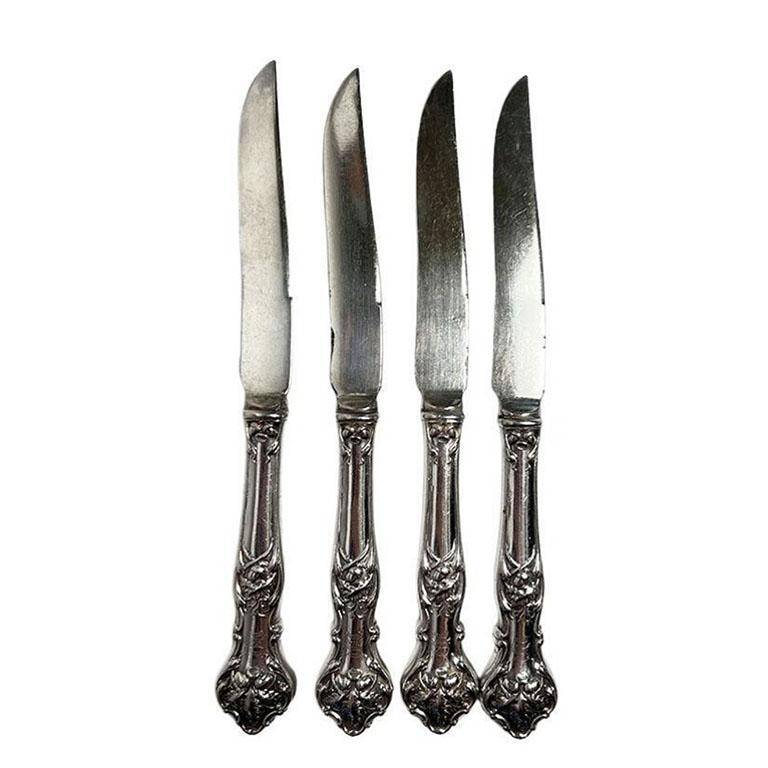 A set of four 1847 Rogers Silverplate hollow handle knives with engraved monogram. This set features a floral pattern design on the handles. To us, it looks to be cabbage leaves and acorns. Each knife is a hollow handle, with an engraved monogram on