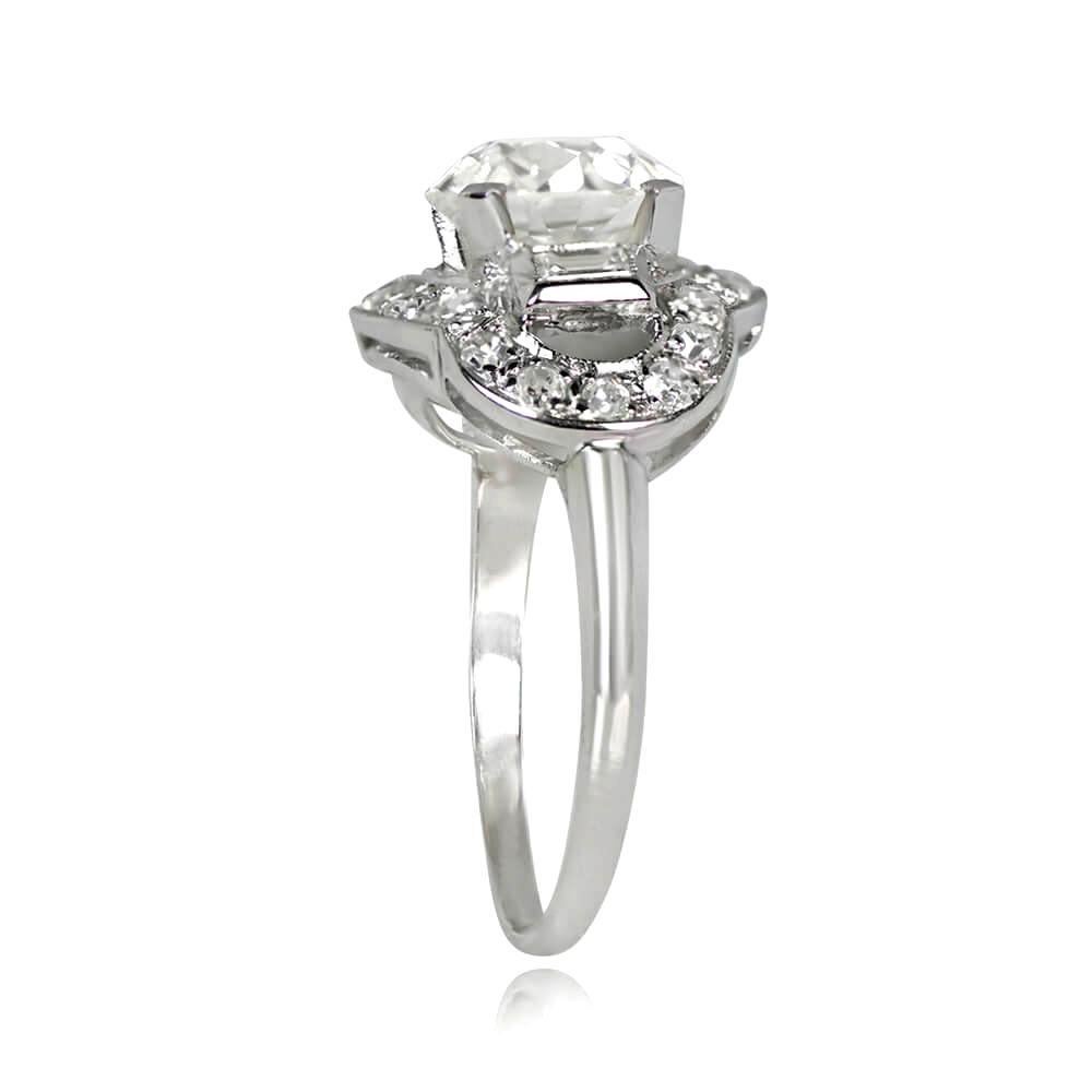 An Art Deco engagement ring showcasing a 1.84-carat old European cut diamond, J color, and VS2 clarity in prong setting, accented by bezel-set baguette-cut diamonds. A single-cut diamond halo encircles the platinum mounting's edge, weighing around