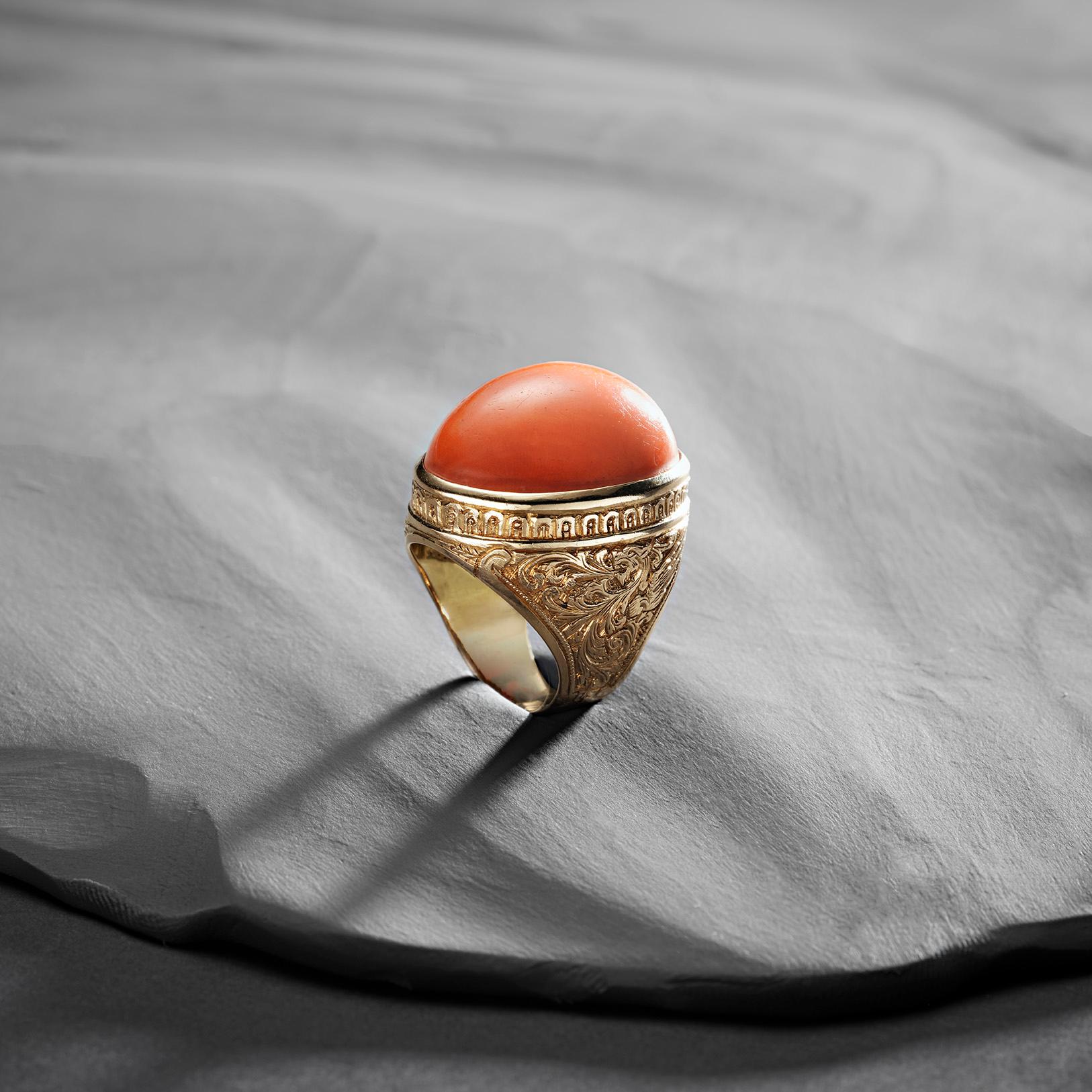Kühn, schön und voller Vintage-Charme - unser Korallen-Gold-Cocktailring ist ein wahres Schmuckstück! Sein Herzstück ist ein üppiger ovaler Korallencabochon, der in warmen, sonnengeküssten Farben leuchtet. Die reiche Goldfassung ist mit
