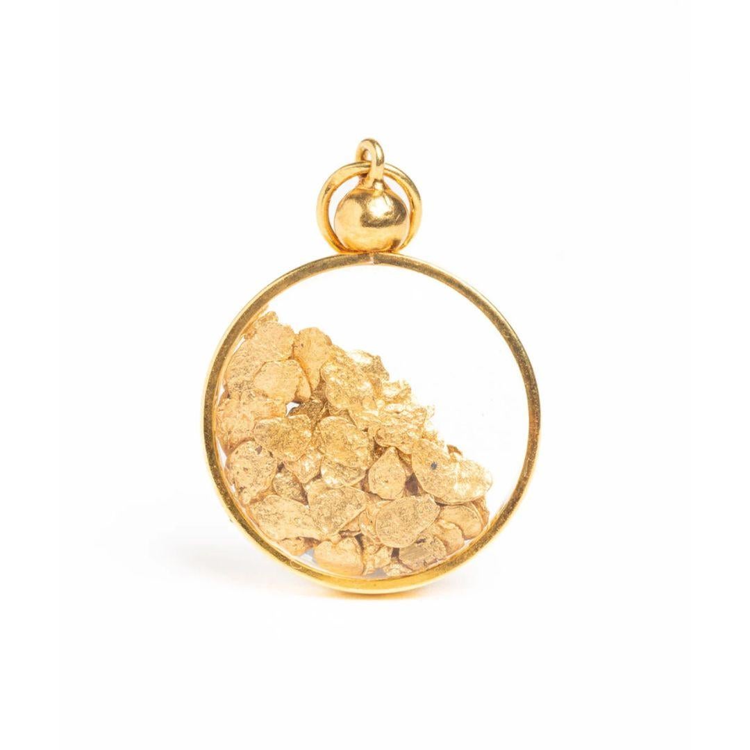 Beautiful and rare oval 18ct gold glass pendant filled with pure 24k gold flakes complete with a hanging bale. Gold mounted 18K/750. This a stunning piece of jewelry that could be a lovely gift for someone special or a great addition to any jewelry