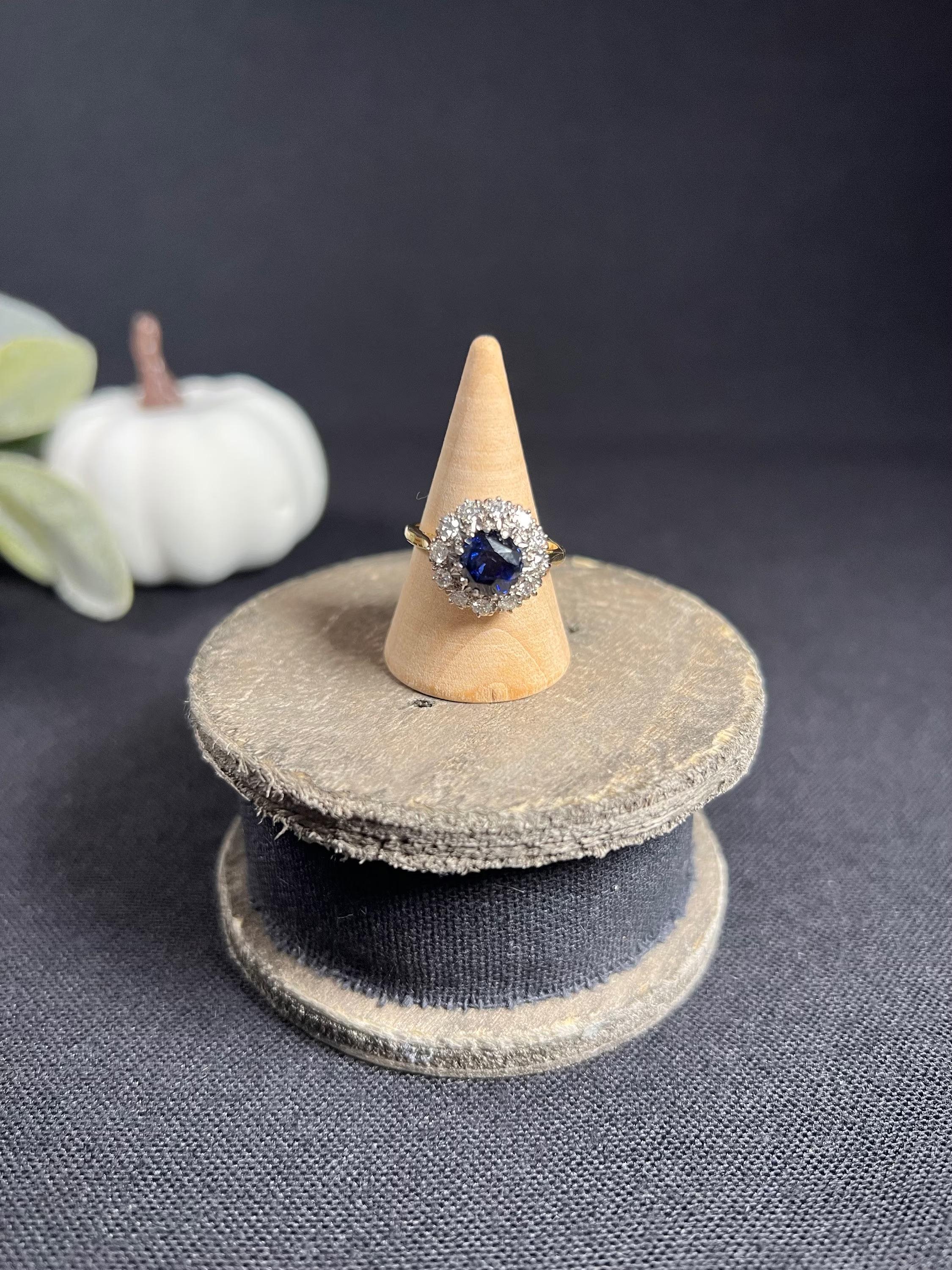 Vintage Cluster Ring

18ct Gold Stamped 

Circa 1960’s 

This 1960s vintage cluster ring is a magnificent piece of jewellery. Crafted from 18ct gold and platinum, it features a stunning faceted natural sapphire centre and a beautiful cluster of