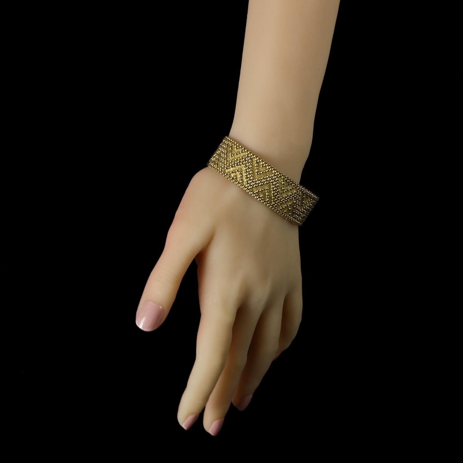 A stylish French 18ct gold woven bracelet by Marchak c.1970s, the bracelet designed as a tightly woven mesh panel with a matte textured gold background formed of hammered links with a contrasting geometric zigzag raised pattern in polished gold