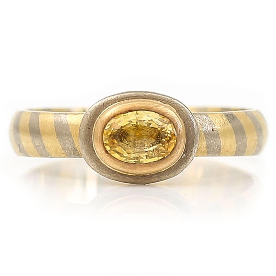 A super stylish and unique vintage 80’s yellow sapphire single stone ring with a two tone, bi-colour 18ct white and yellow gold band. An ideal ring for those who like something different or who simply love to wear both yellow and white gold, this