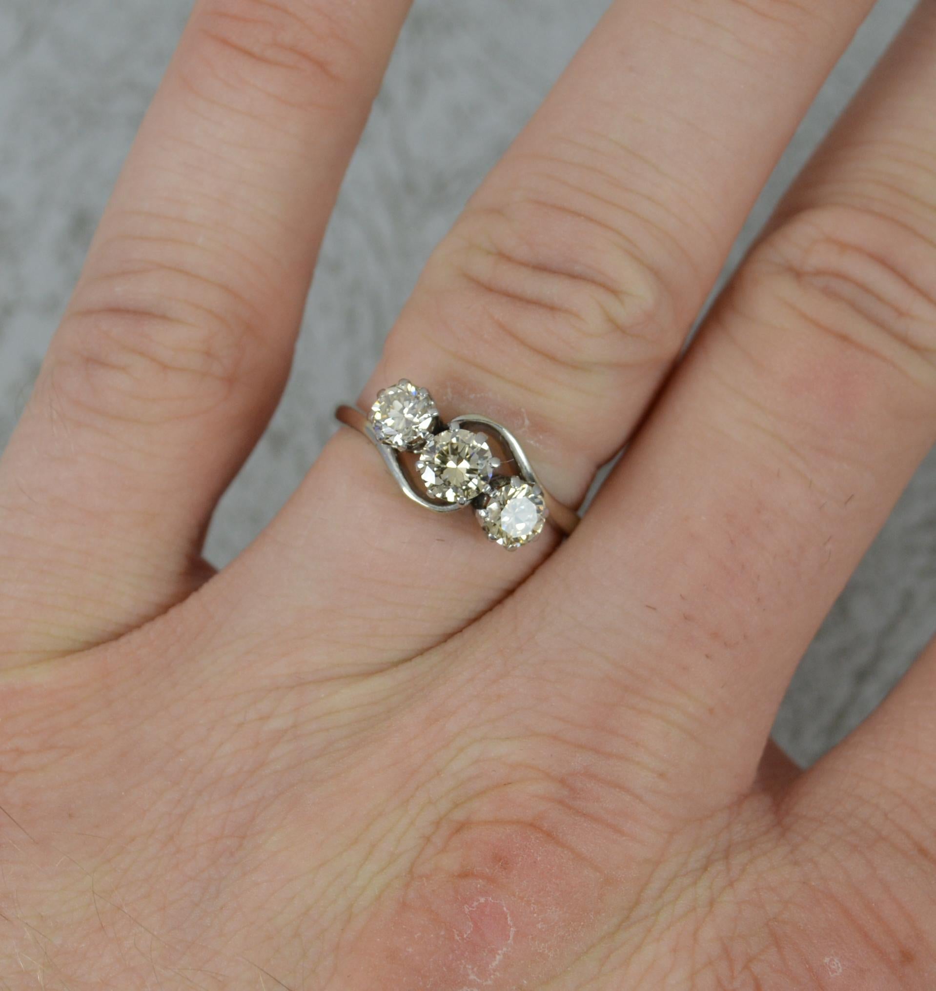 A fine natural diamond three stone ring.
Solid 18 carat white gold shank and platinum claw settings.
Set with three natural round brilliant cut diamonds to total 1 carat. Set in multi claw settings on a twist.
Sparkly, natural diamonds with a light