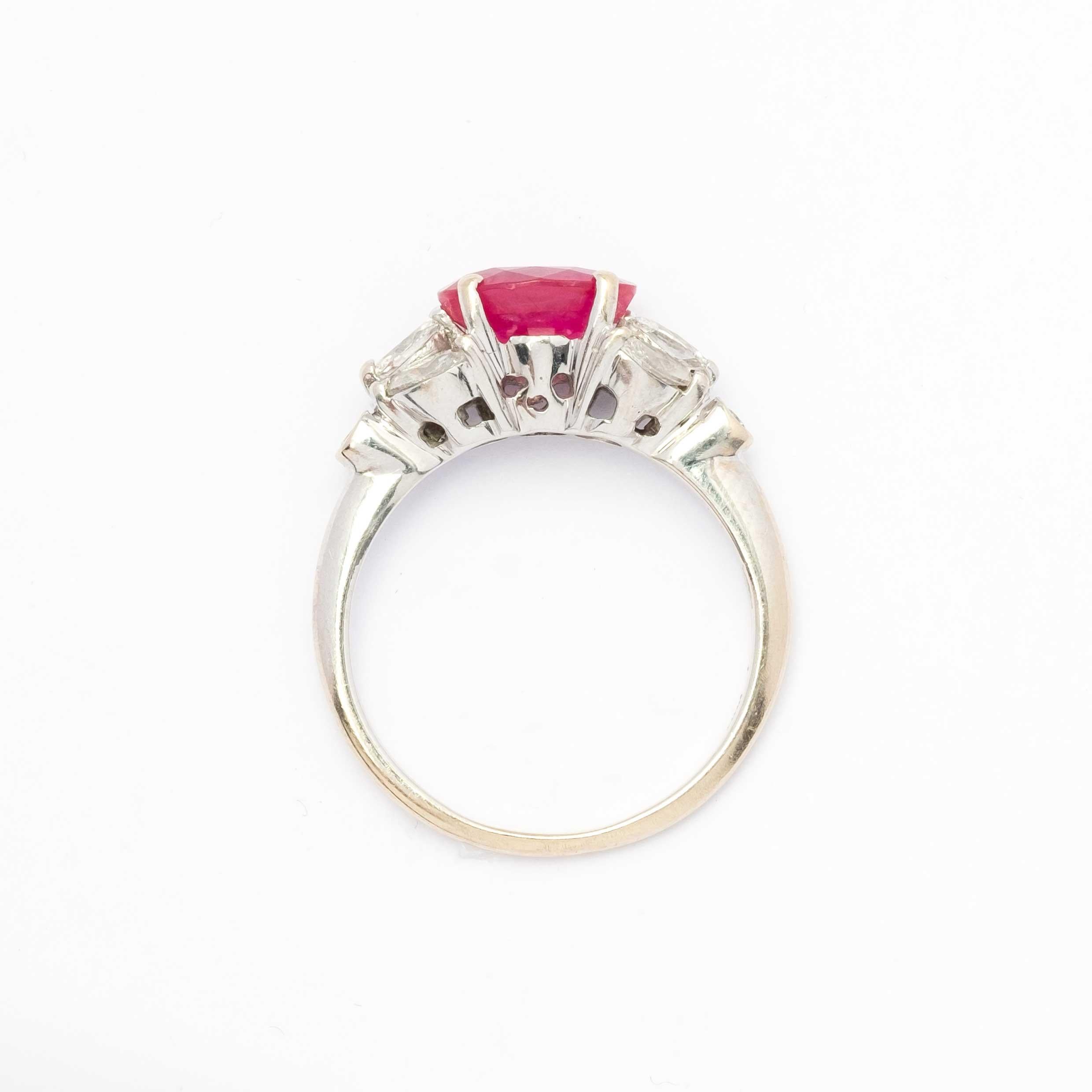 Un elegante anello vintage in oro bianco 18 ct (punzonato 750), dal design raffinato e armonioso. Al centro si trova un rubino naturale riscaldato di circa 2 carati, con una tonalità intensa e vibrante. L'incastonatura è ulteriormente arricchita da