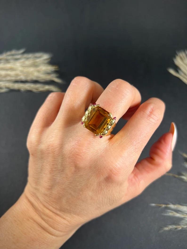 Citrine Cocktail Ring 

18ct Yellow Gold Tested

Circa 1940s

This stunning 18ct yellow gold cocktail ring is sure to turn heads. The ring features a fabulous emerald-cut citrine stone that catches the light beautifully. The citrine stone is