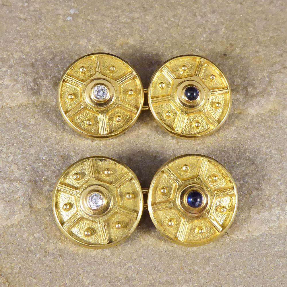 With a wheel like aesthetic to each of the cufflinks, it has a pattern of 6 panels with a ball inside of each. All circling either a Diamond or Cabochon Sapphire, one in each set of cufflinks modelled in 18ct Yellow Gold.

Condition: Good, slightest