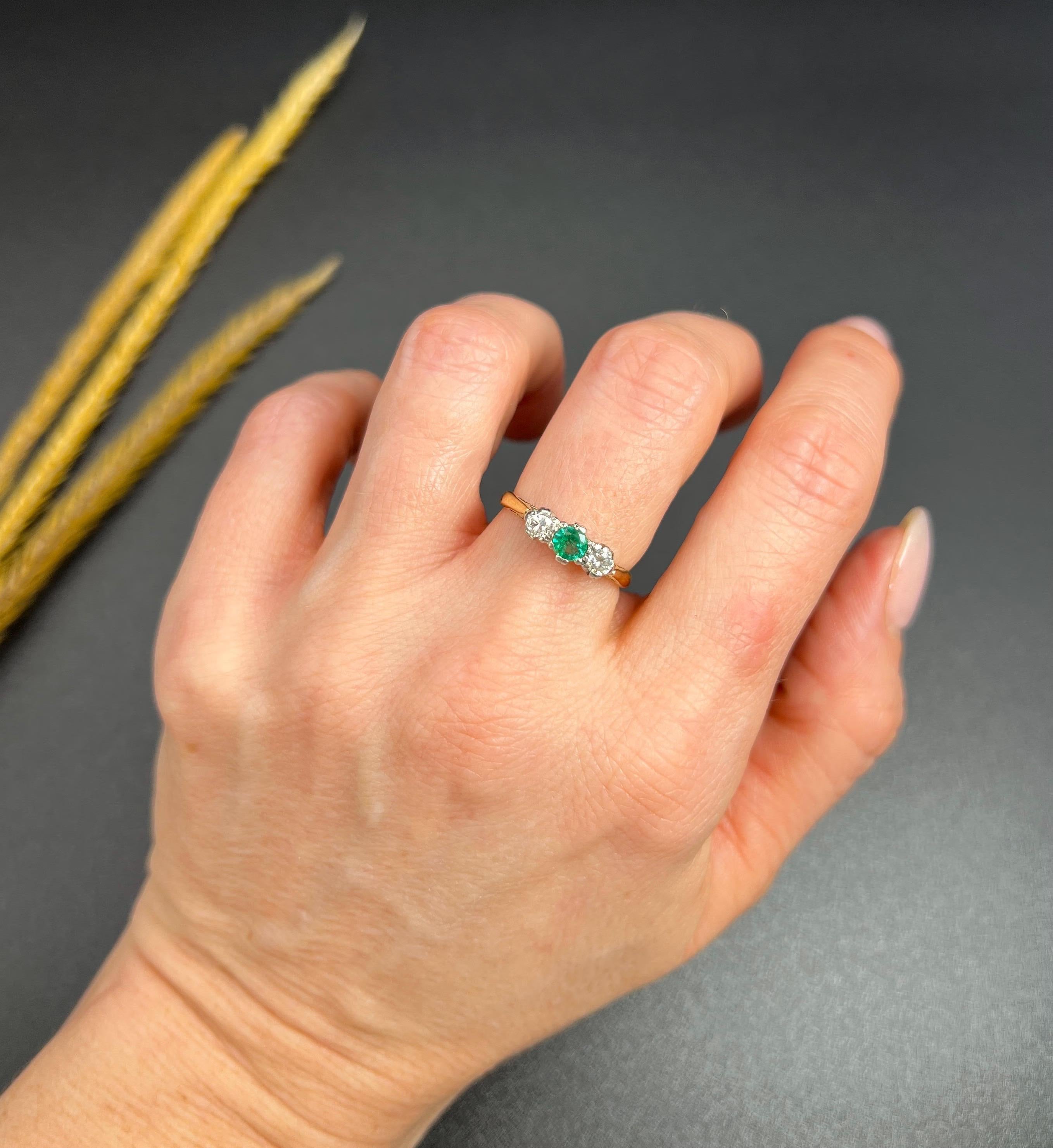 Vintage Emerald & Diamond Trilogy Ring

18ct Gold & Platinum

Circa 1950s

This stunning trilogy ring from the 1950s is a true vintage beauty. The ring is crafted in 18ct yellow gold and features a natural emerald and two natural diamonds. The
