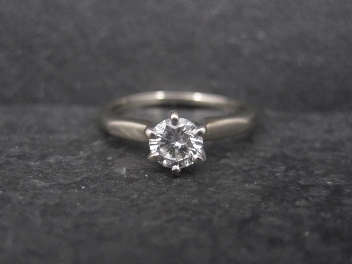 This beautiful vintage engagement ring is 18k white gold.
It features a .33 carat round cut diamond estimated to be G in color and SI1 in clarity.

Size: 4

Marks: 18K