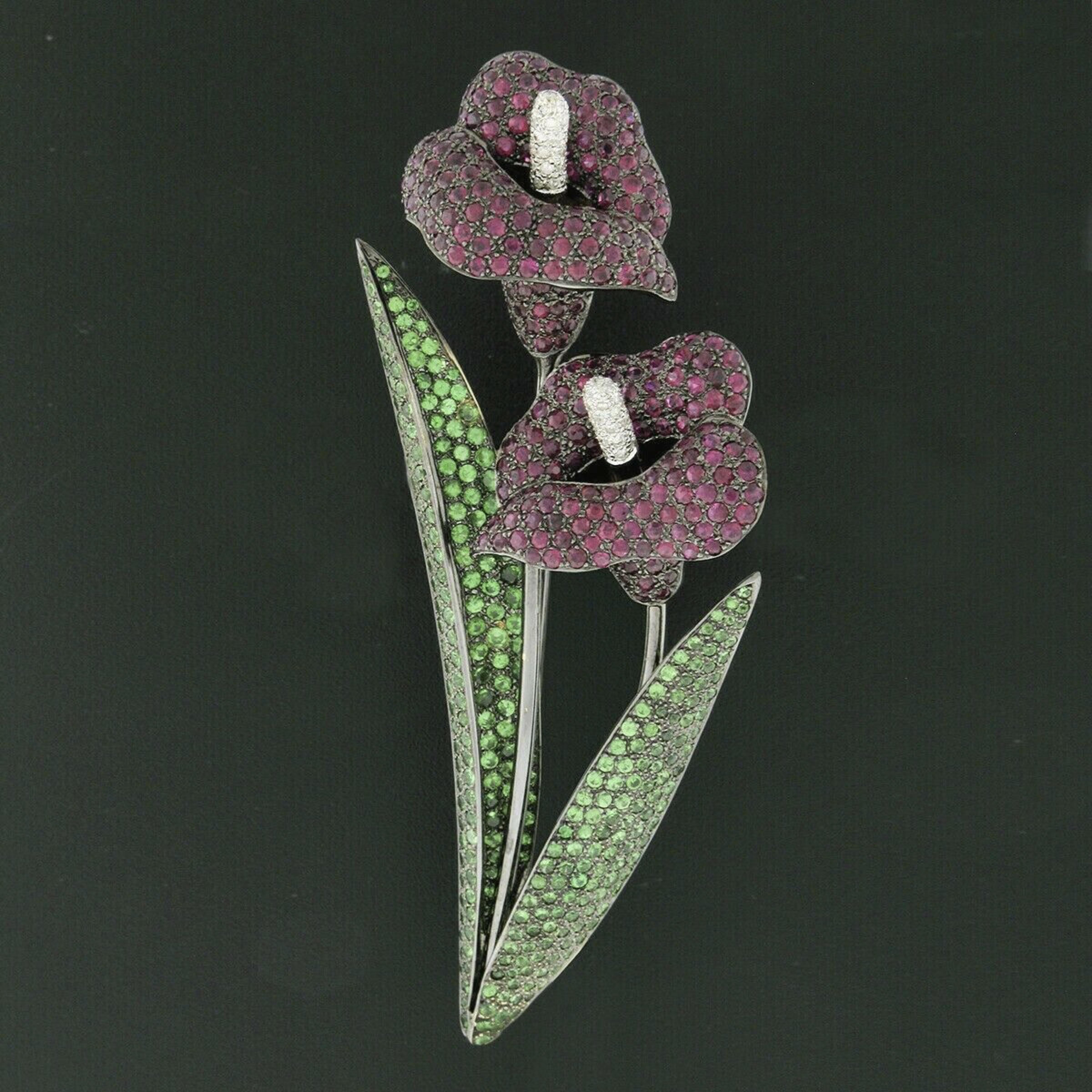 Here we have a large vintage brooch that was crafted from solid 18k white gold with black rhodium top. This large brooch features dual calla lily flower design that is set with over 18 carats of truly pavé set round cut gemstones and diamonds. There