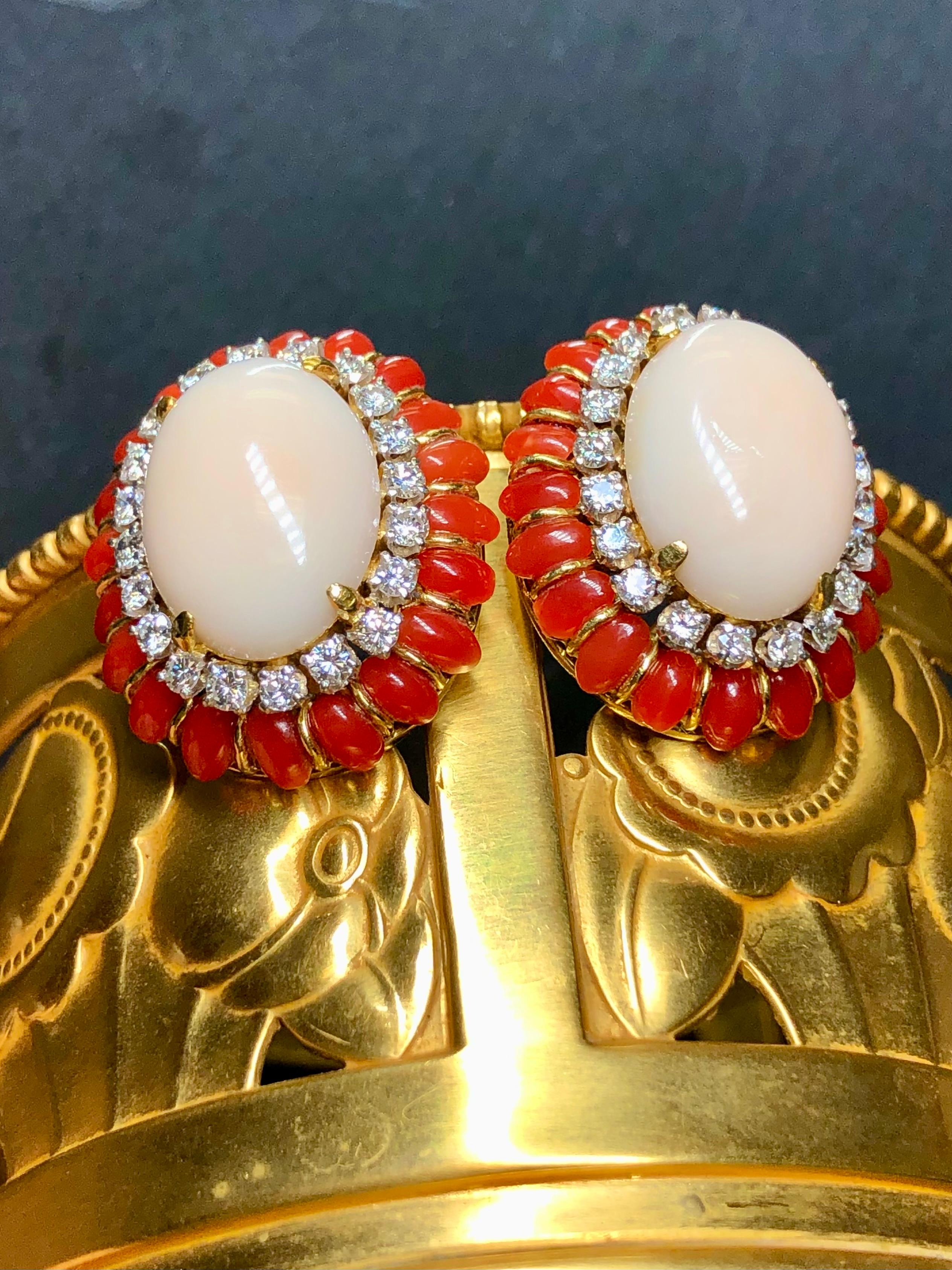 An absolutely stunning pair of earrings c. the late 1960’s done in 18K yellow gold (14K omega backs) with large central angel skin coral cabochons surrounded by smaller, deep red coral cabochons. In between the coral is approximately 2cttw in G-I