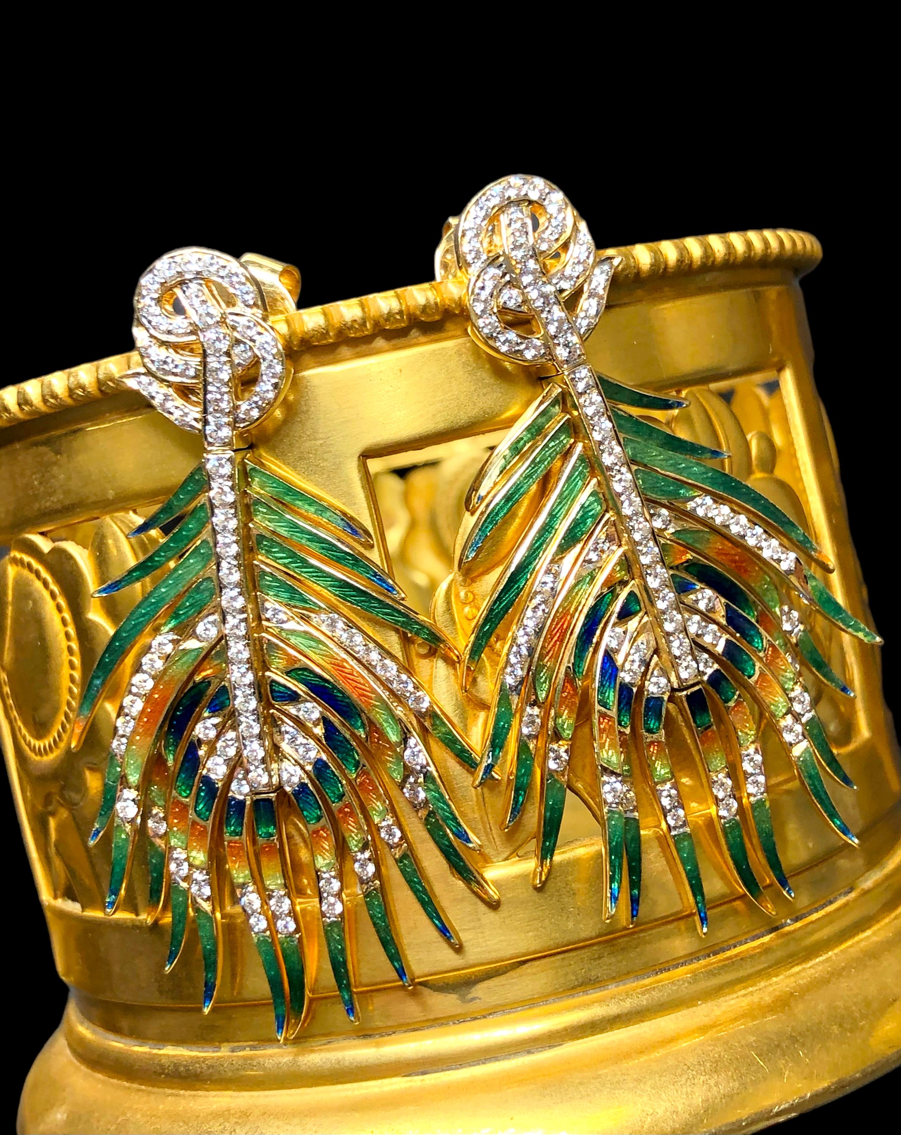 
An exceptional pair of vintage 1960’s earrings hand crafted in 18K yellow gold and finished in multicolored enamel achieving the look a beautiful peacock feathers. Each articulating section as well as going up the center are bead set G-I color