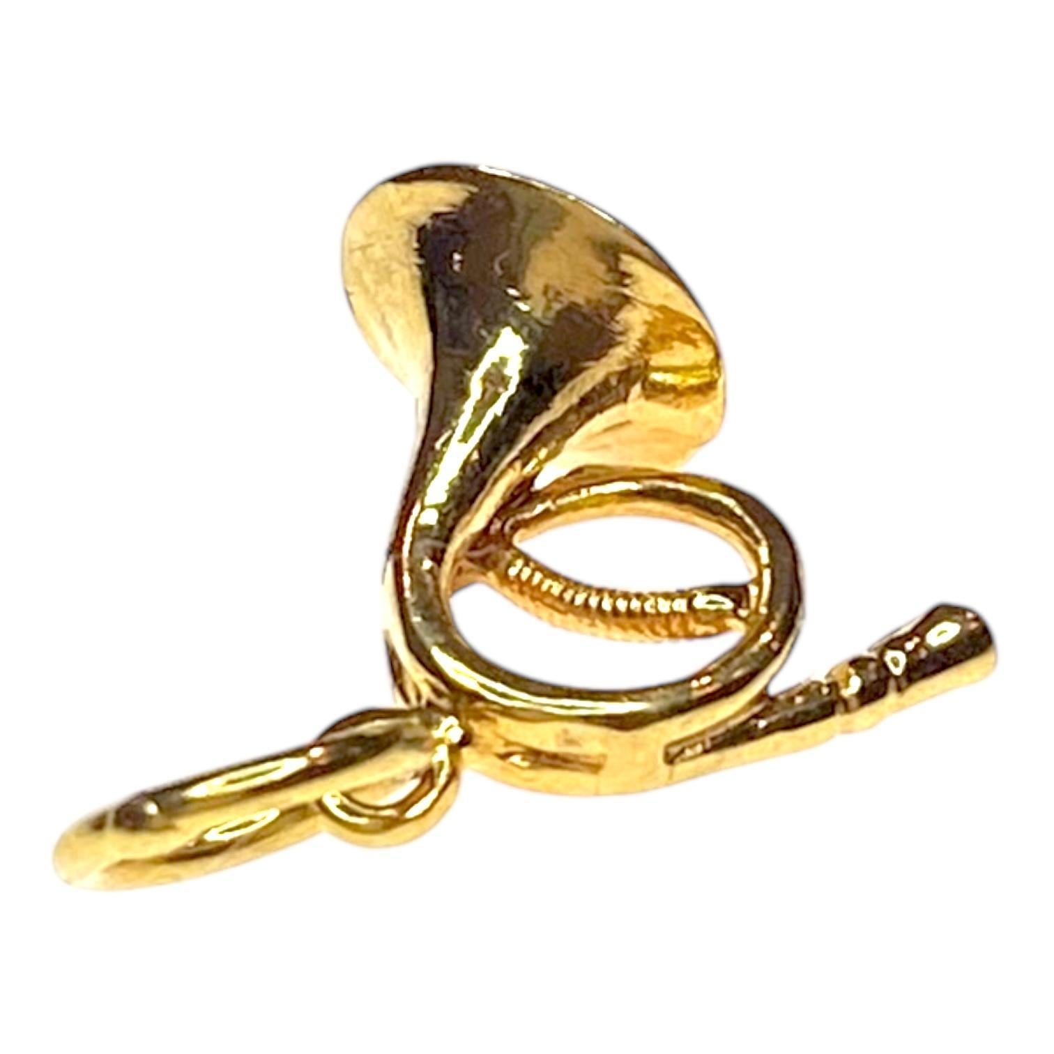 Realizzato in oro giallo 18 carati, questo charm presenta un disegno dettagliato di un corno francese. Le curve intricate e la finitura lucida evidenziano la forma elegante dello strumento. 
Misure:
Lunghezza: 17.0 mm (compresa la
