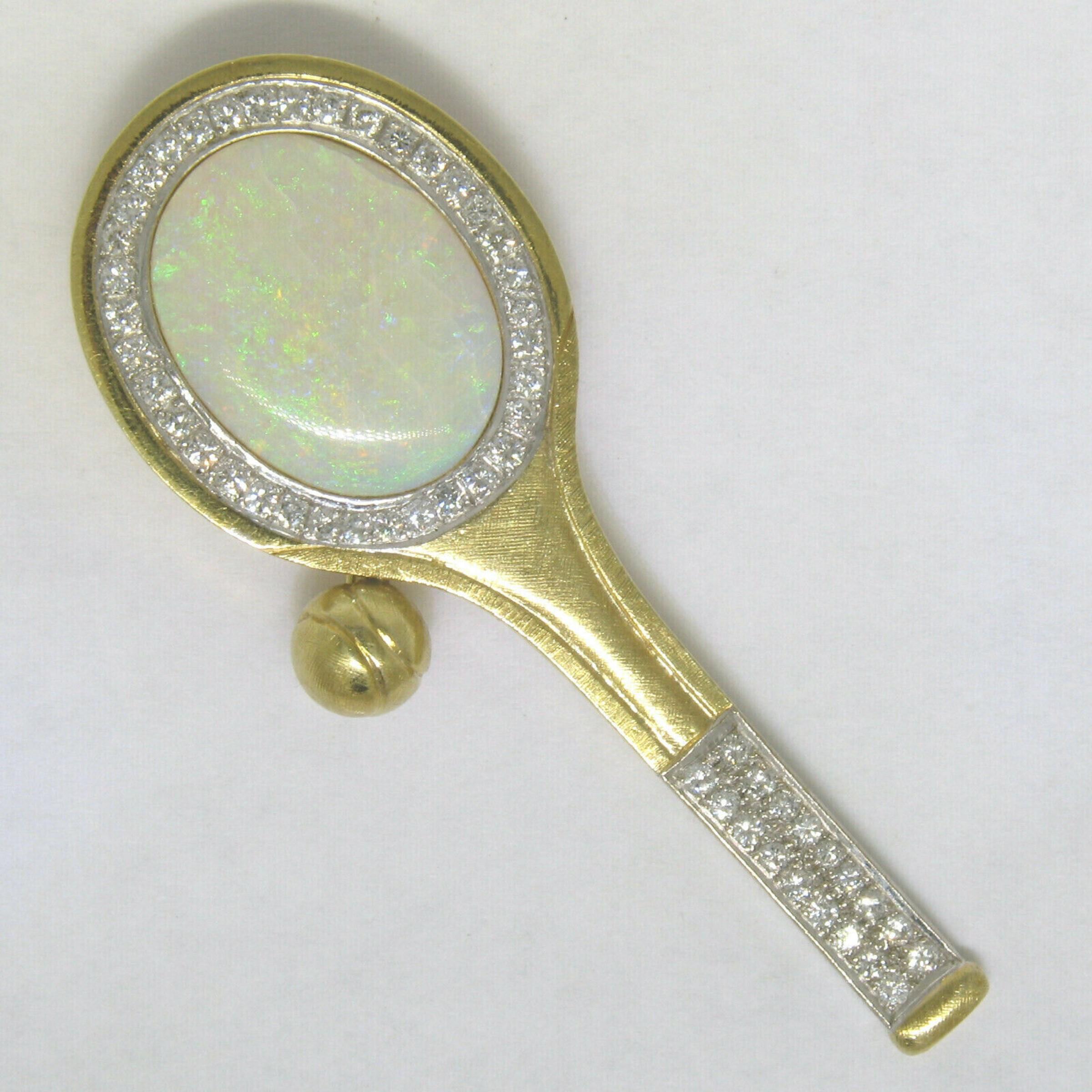 You are looking at an amazingly designed tennis racket brooch or pendant crafted in solid 18k yellow gold featuring a large, very colorful, oval cabochon opal. The Australian opal stone displays tremendous amounts of color play over the translucent