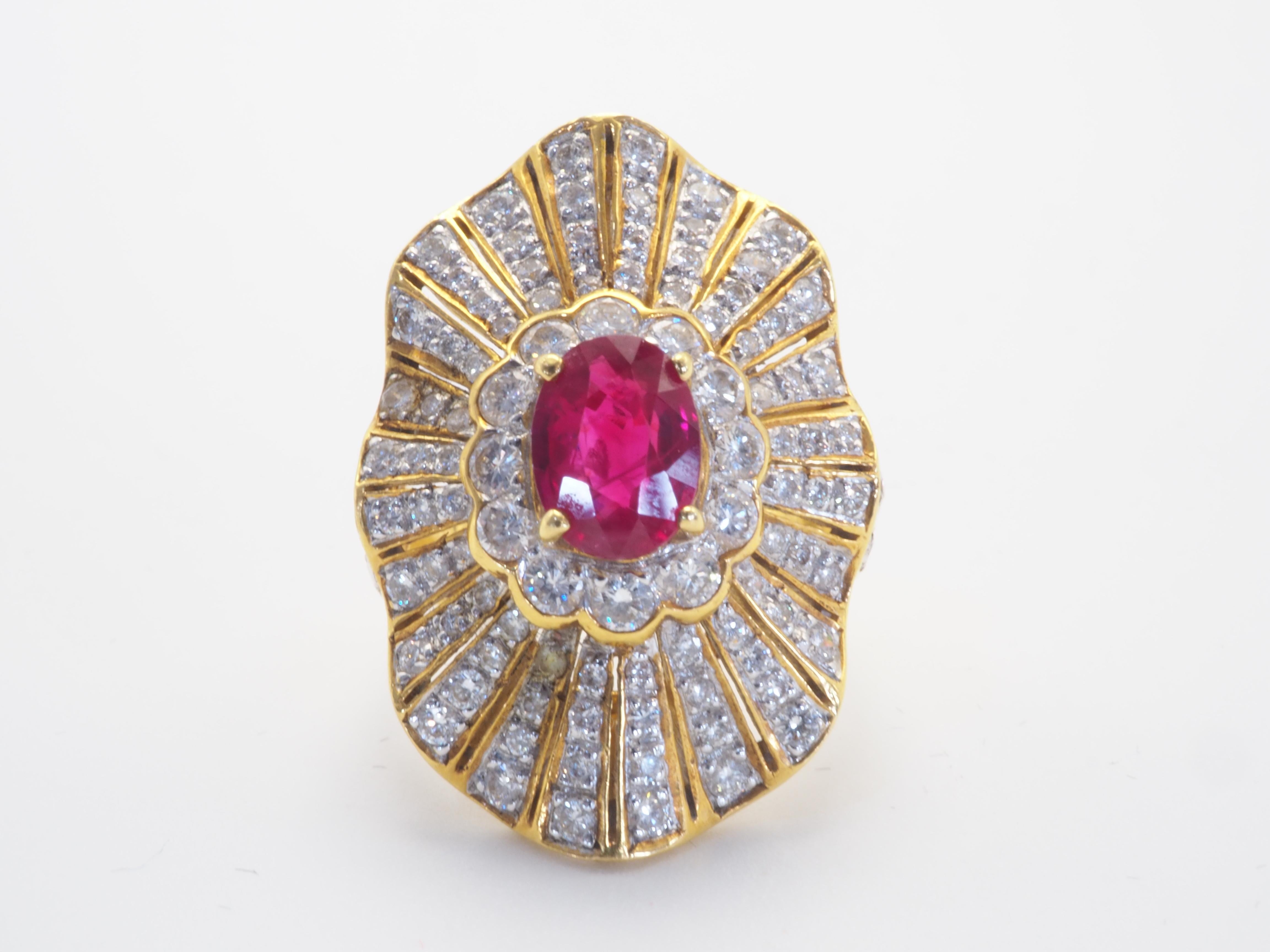 This wonderful cocktail shield ring boasts a fiery red oval cut ruby of 1.25 carats. The stunning oval cut ruby is sparkly and refractive with natural surface inclusion which is set in the middle of brilliant round cut diamonds of generally white