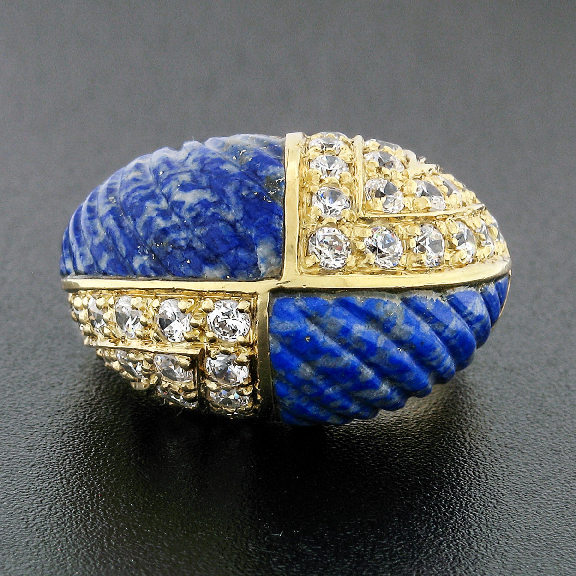 This beautiful vintage bombé ring was crafted from solid 18k yellow gold. It features a round dome with four sections, two of which display lapis that are carved with lined grooves, and the other two displaying round brilliant diamonds. The lapis