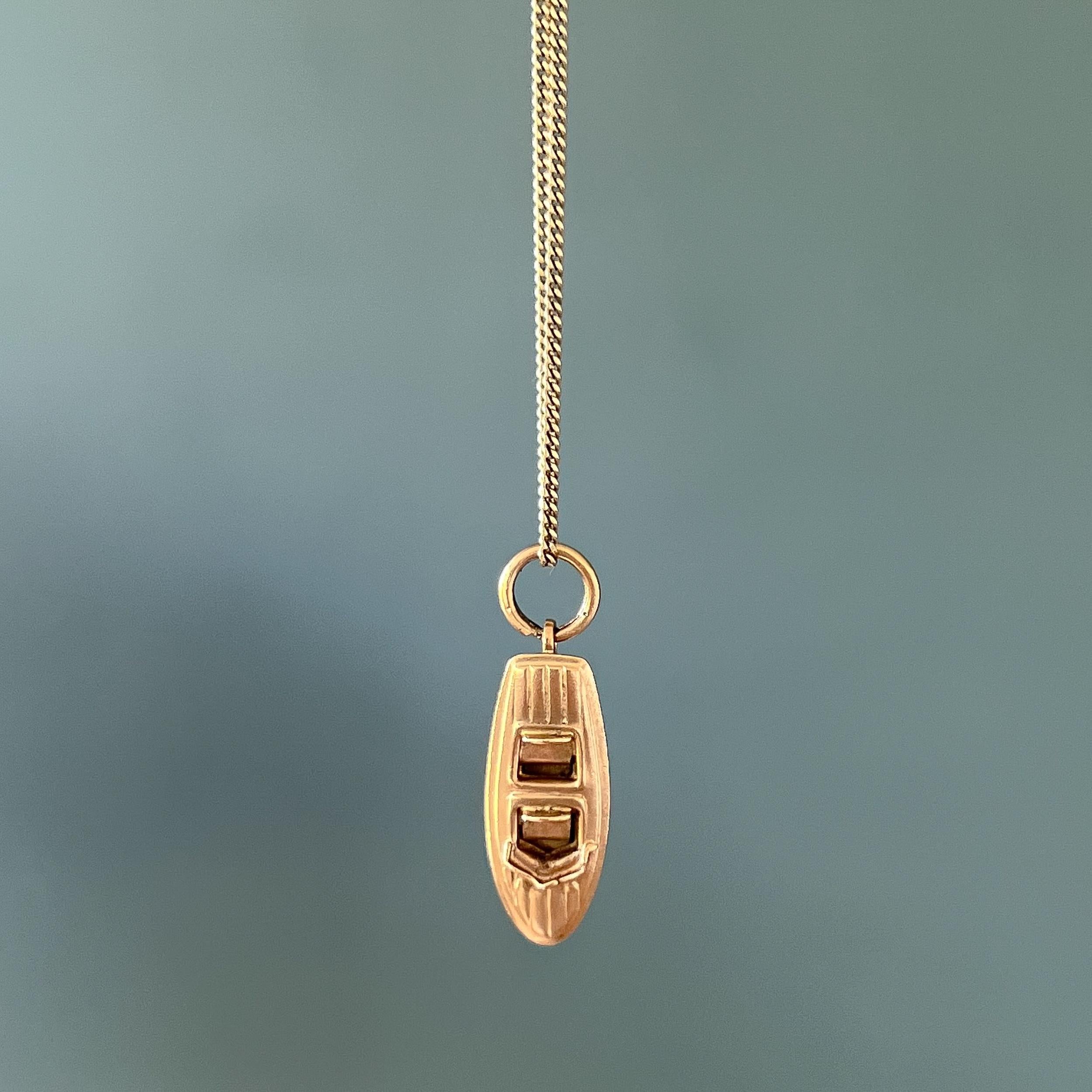 A vintage 18 karat yellow gold Italian speedboat charm pendant. This vintage 1960s streamlined speedboat has some very great details. The top of the motorboat has a pattern that resembles a wooden deck and the boat is equipped with a driver's seat