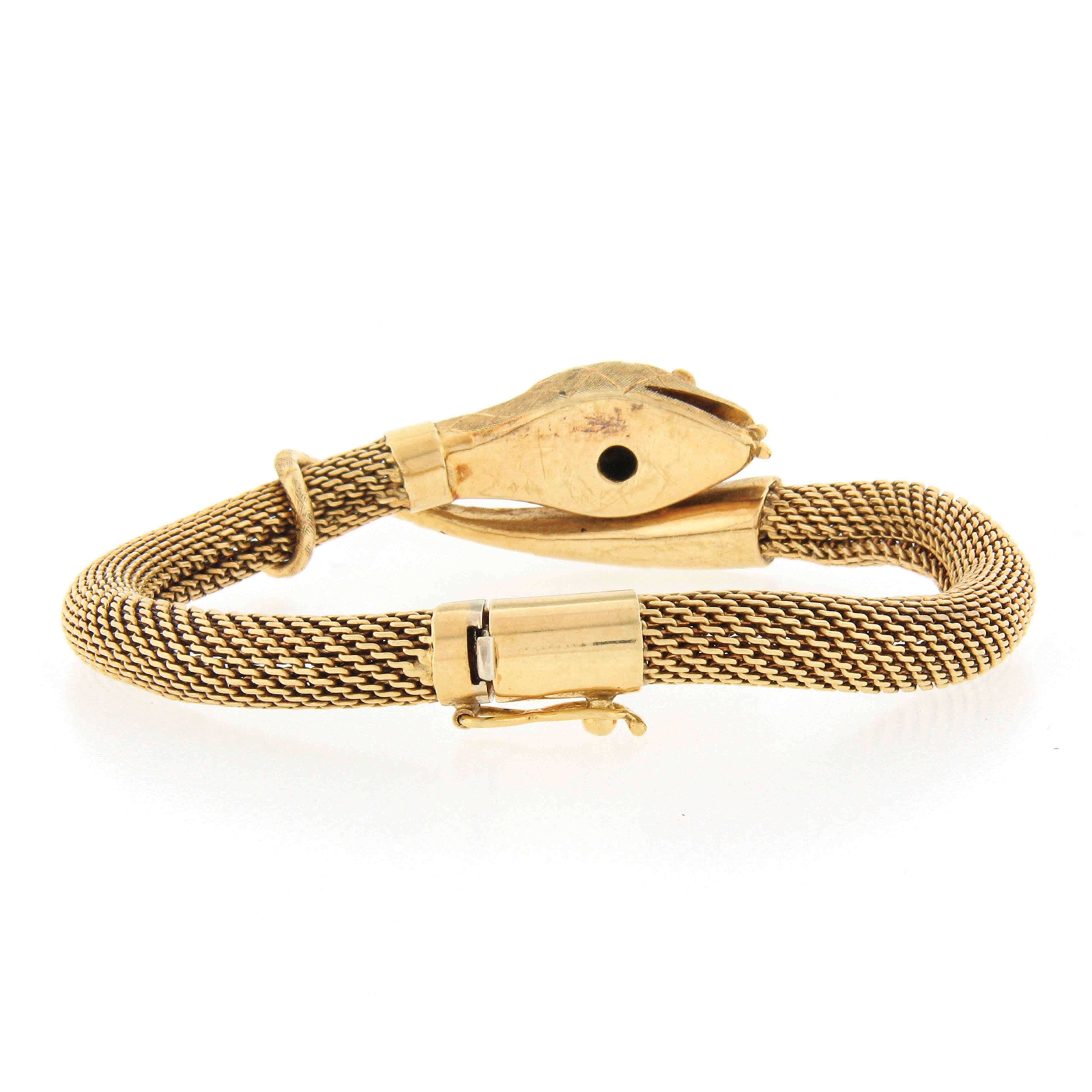 This incredible vintage tube mesh bangle bracelet was crafted from solid 18k yellow gold and features a unique style of a snake wrap that's beautifully detailed with wonderful textured finish throughout. The snakes head is neatly bezel set with a