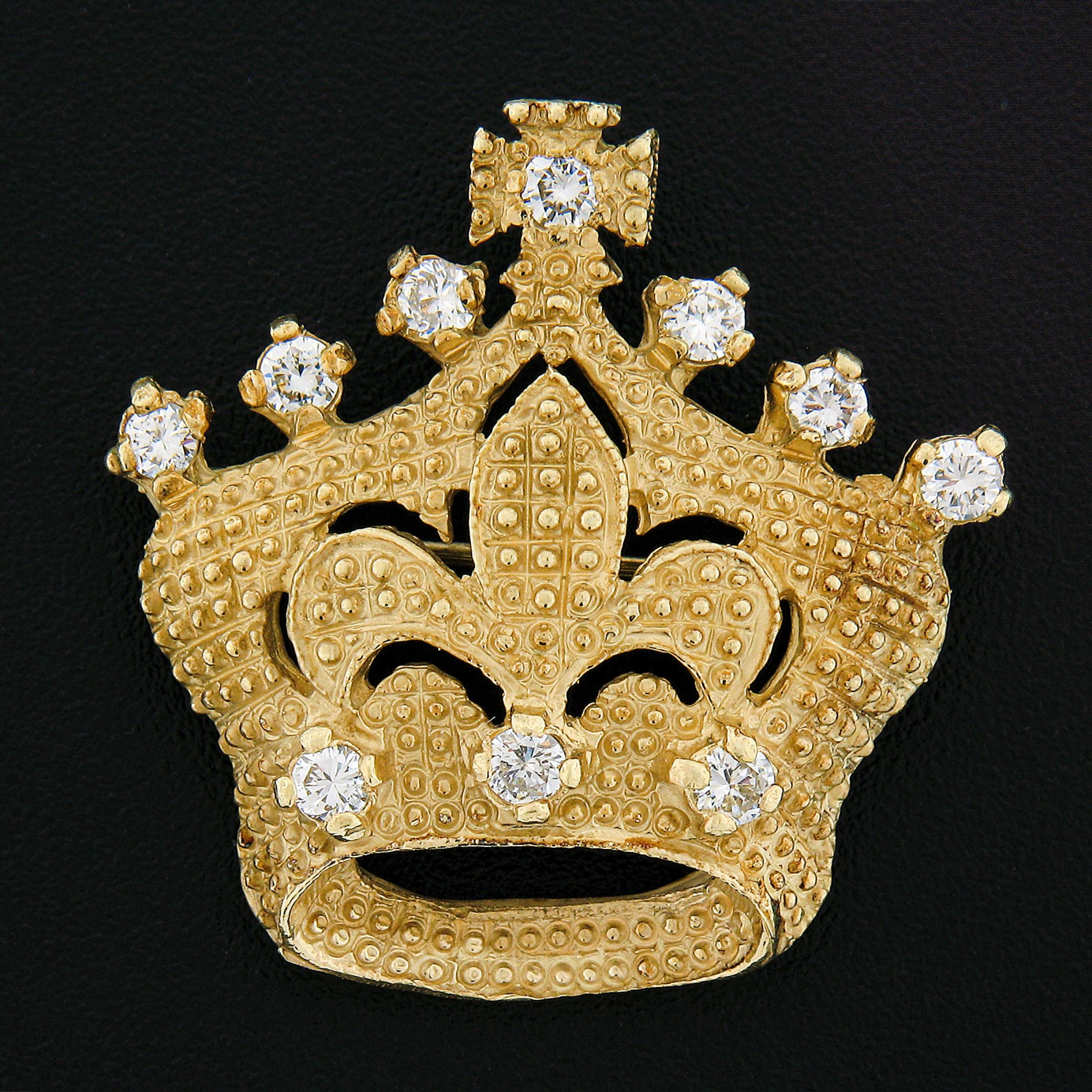 A well made pin/brooch which was crafted from solid 18k gold. The piece features a crown with Fleur De Lis design at the center and a cross at the top of the crown. The crown has a textured beaded finish adding a unique touch to this piece. The
