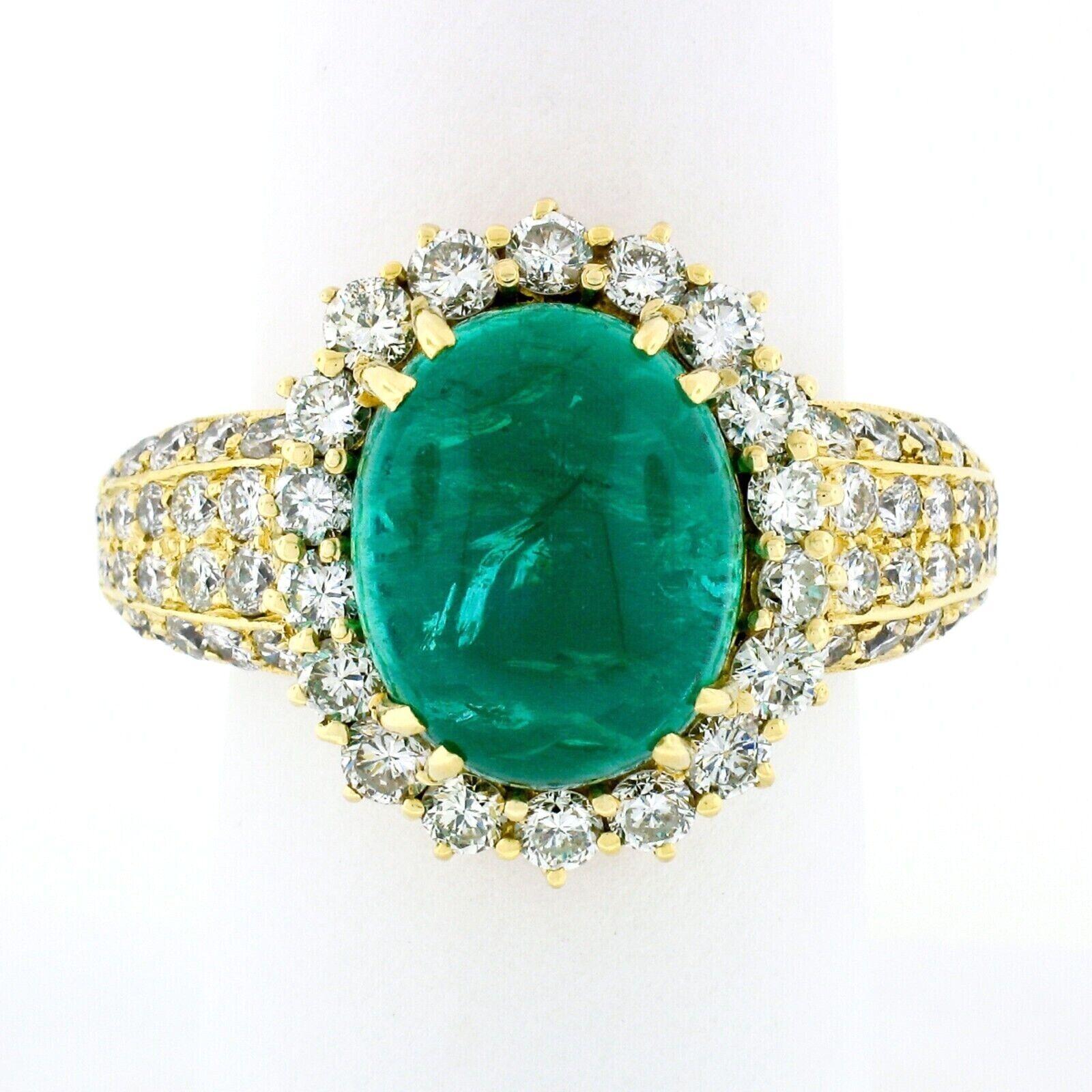 This gorgeous, vintage, AGL certified emerald and diamond cocktail ring was crafted from solid 18k yellow gold. It features a breathtaking, natural, oval cabochon cut emerald that displays a very rich and lively green color. The stone is dual prong