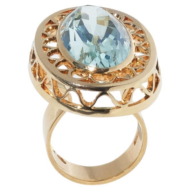 This 18 karat gold ring is adorned with an oval cut aquamarine. The setting is prominent, being shaped like something that resembles a collar from the 16th century. The shank is wide and plays an important part in the design of the ring.

This is an