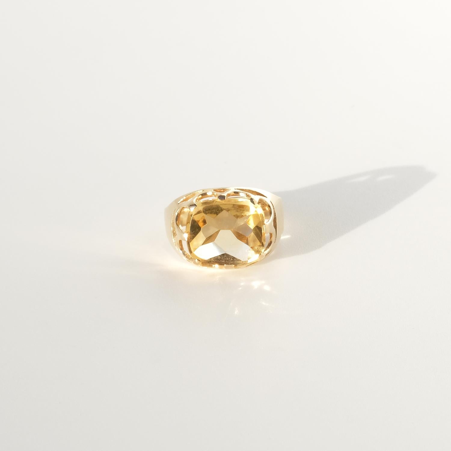 Dieser Ring aus 18-karätigem Gold zeigt einen leuchtenden, facettenreichen Citrin, der in einer komplizierten, durchbrochenen Fassung gefasst ist, die an fließende Wellen erinnert und das Licht den goldenen Glanz des Edelsteins zur Geltung bringt.