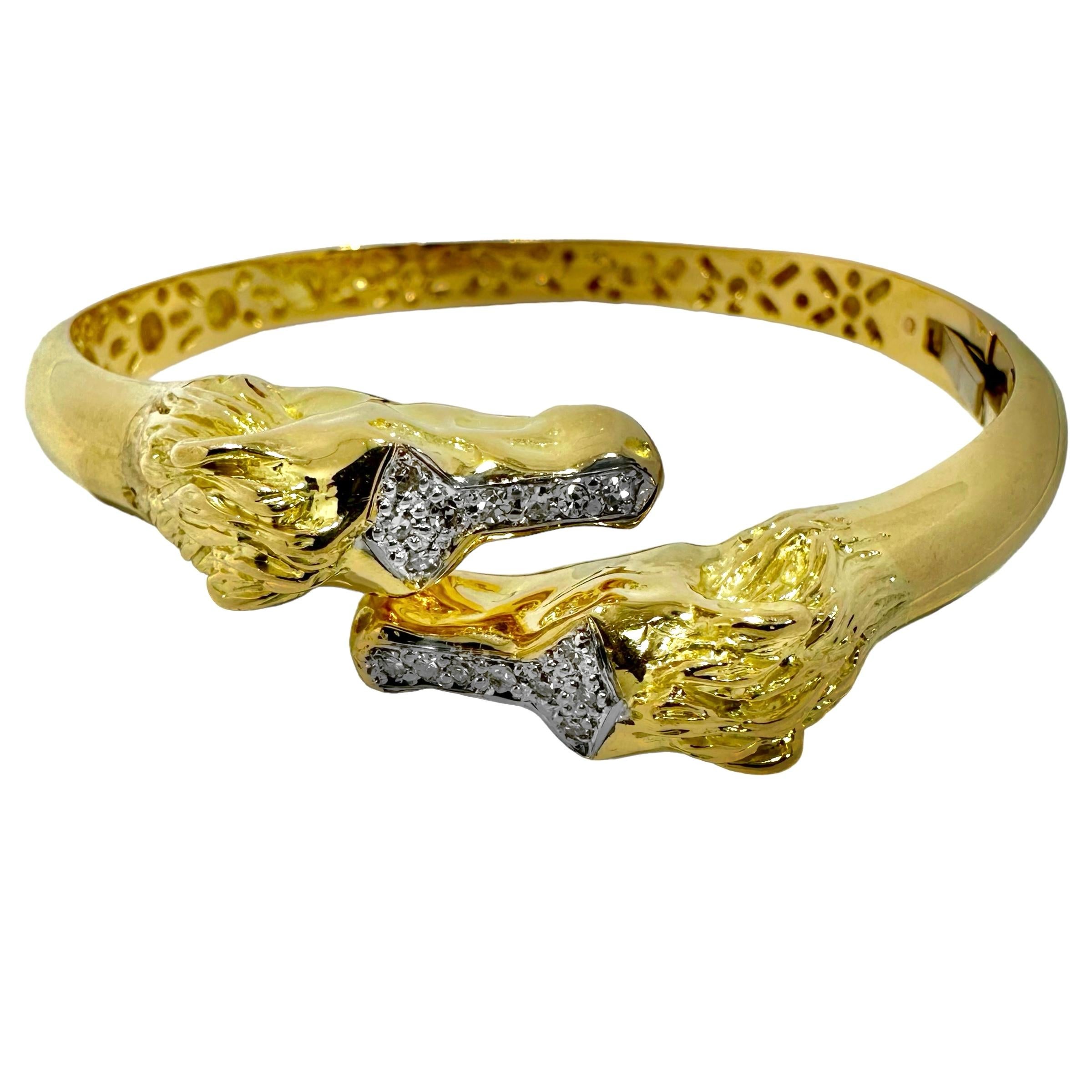 This lovely vintage 18k yellow gold hinged bangle bracelet features two well detailed equestrian heads bypassing each other. This type of bypass bracelet is truly a perennial favorite. Lifelike horse caricatures with flowing manes are set with a