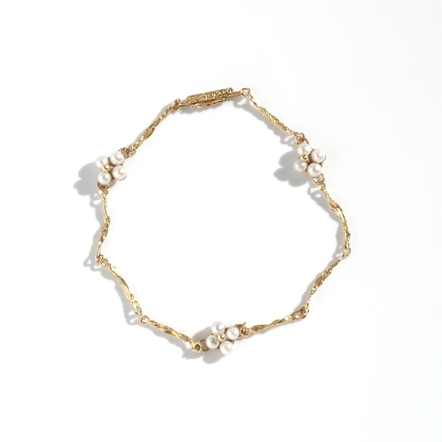 Dieses Vintage-Armband mit dem Namen Wild Flower ist aus 18 Karat Gold gefertigt und mit Zuchtperlen besetzt. Die Kette besteht aus einzeln gearbeiteten Gliedern mit einer organischen, strukturierten Oberfläche, die zu einer filigranen und doch