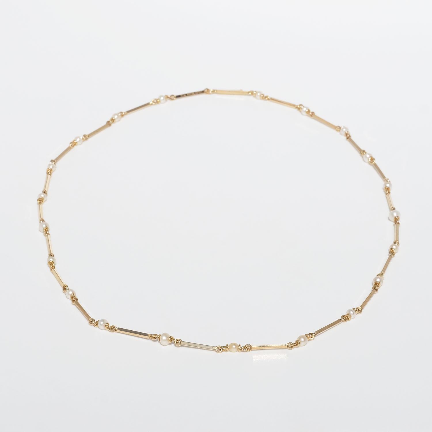 This 18 karat gold necklace is made of rectangular gold bars which are linked together. Each link is embraced by cultured pearls. The gold has a shiny surface. The necklace closes easily with a hook.

The necklace is perfect for the everyday