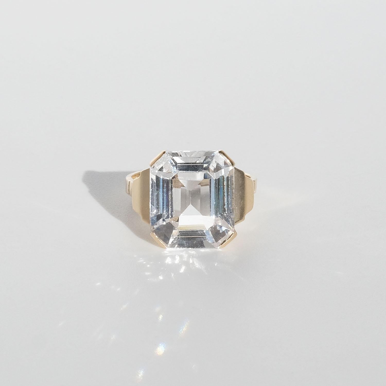 Dieser Ring aus 18-karätigem Gold mit Bergkristall und schöner Fassung weist typische Merkmale dieser Zeit auf, wie die hervorstehenden Schultern und den facettierten Bergkristall. Die fast quadratische Form des Bergkristalls in einer durchbrochenen