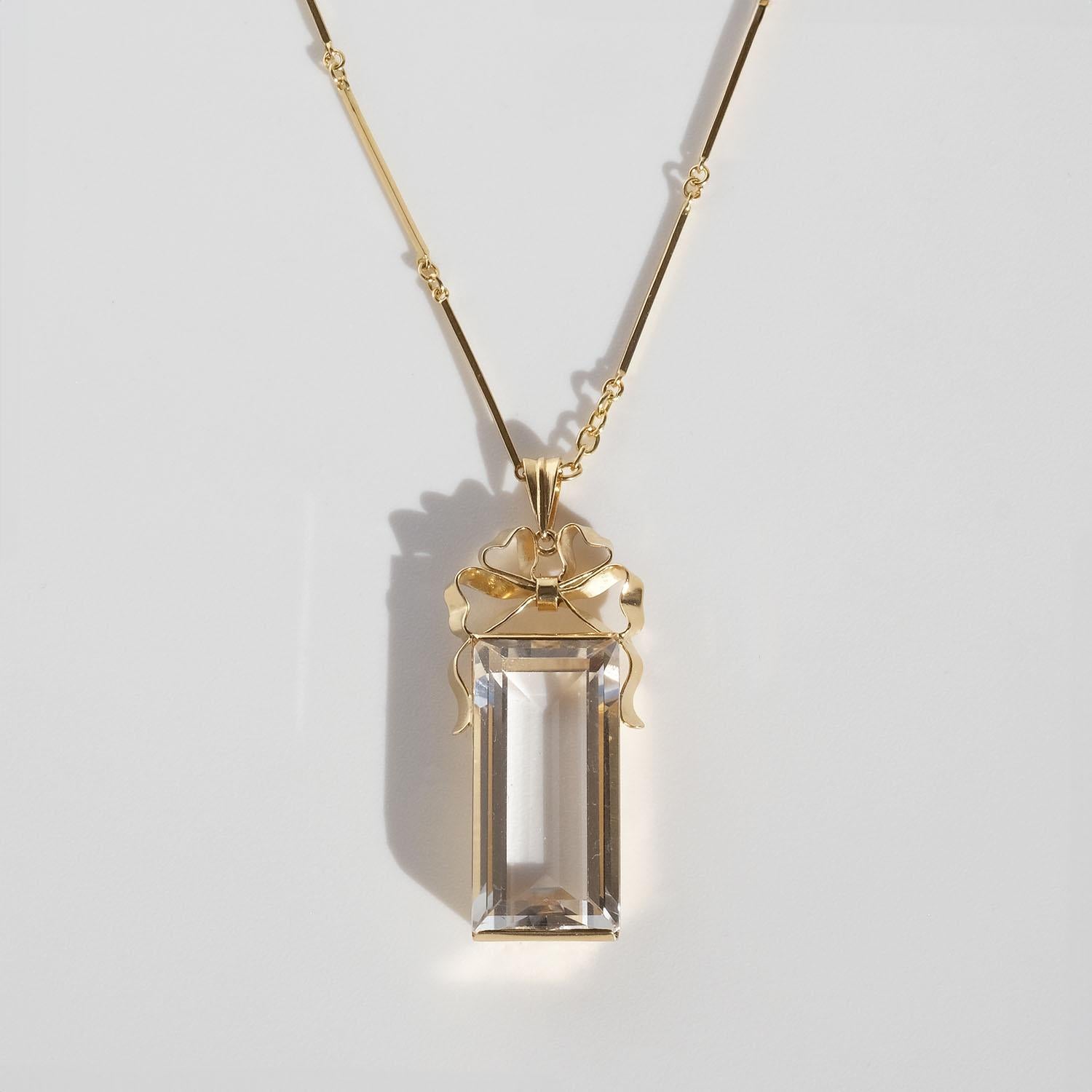 This 18 karat gold and rock crystal necklace shows upon typical characteristics for this time, such as the ring and bar chain and the pendant with its straight geometric shapes, its shiny surface and emerald-cut rock crystal. Something that makes