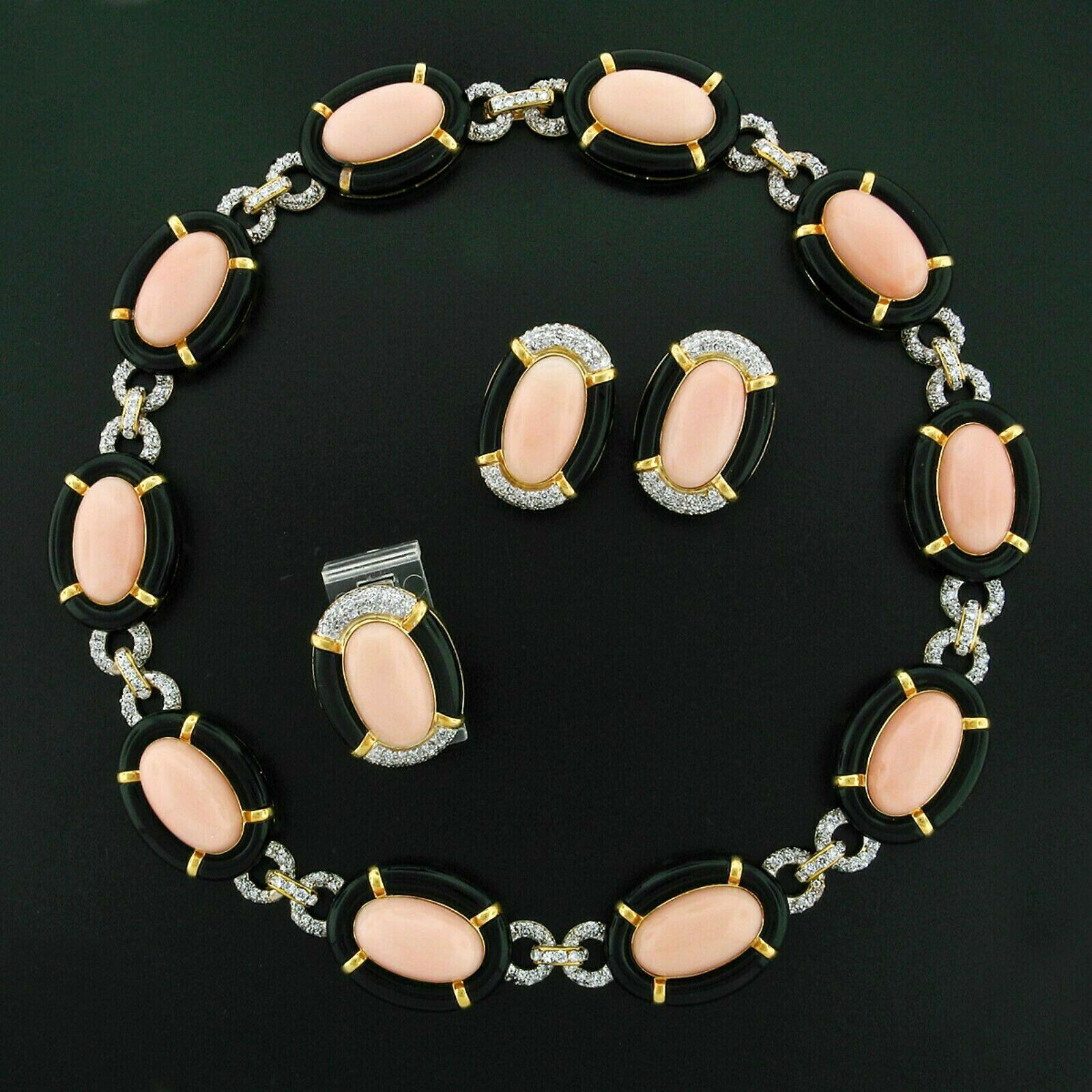 Here we have an outstanding vintage jewelry set crafted from solid 18k yellow and white gold. The set consists of a ring, earrings, and a necklace all made in the same coral, black onyx, and diamond pattern. 

The ring has an oval cabochon coral